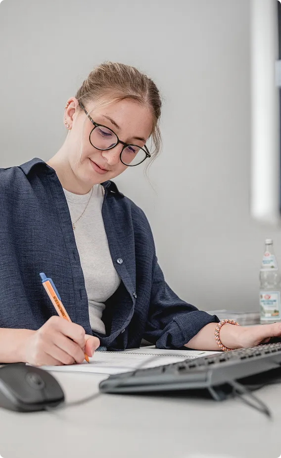 Mitarbeiterin arbeitet am Schreibtisch