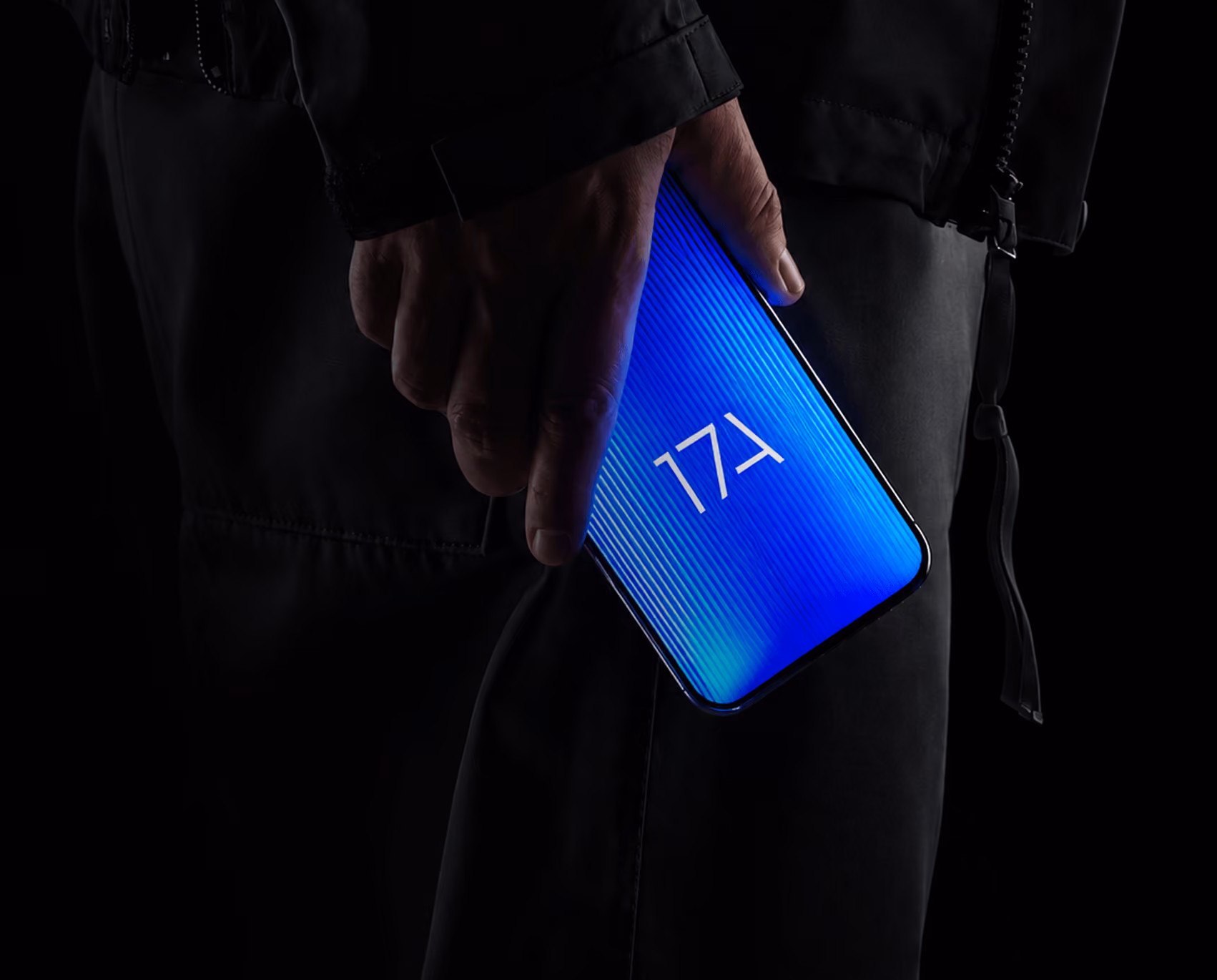 Hand holding a smartphone with the glowing blue 17A logo on screen, against a dark background.