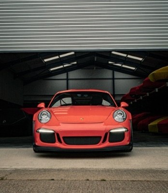 Supercar exiting the secure, monitored warehouse gate at Auto Classica in Milton Keynes.