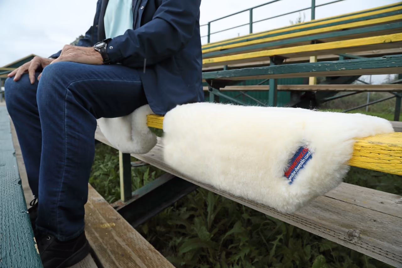 Bumwarmer sheepskin seat cushion on stadium bleachers