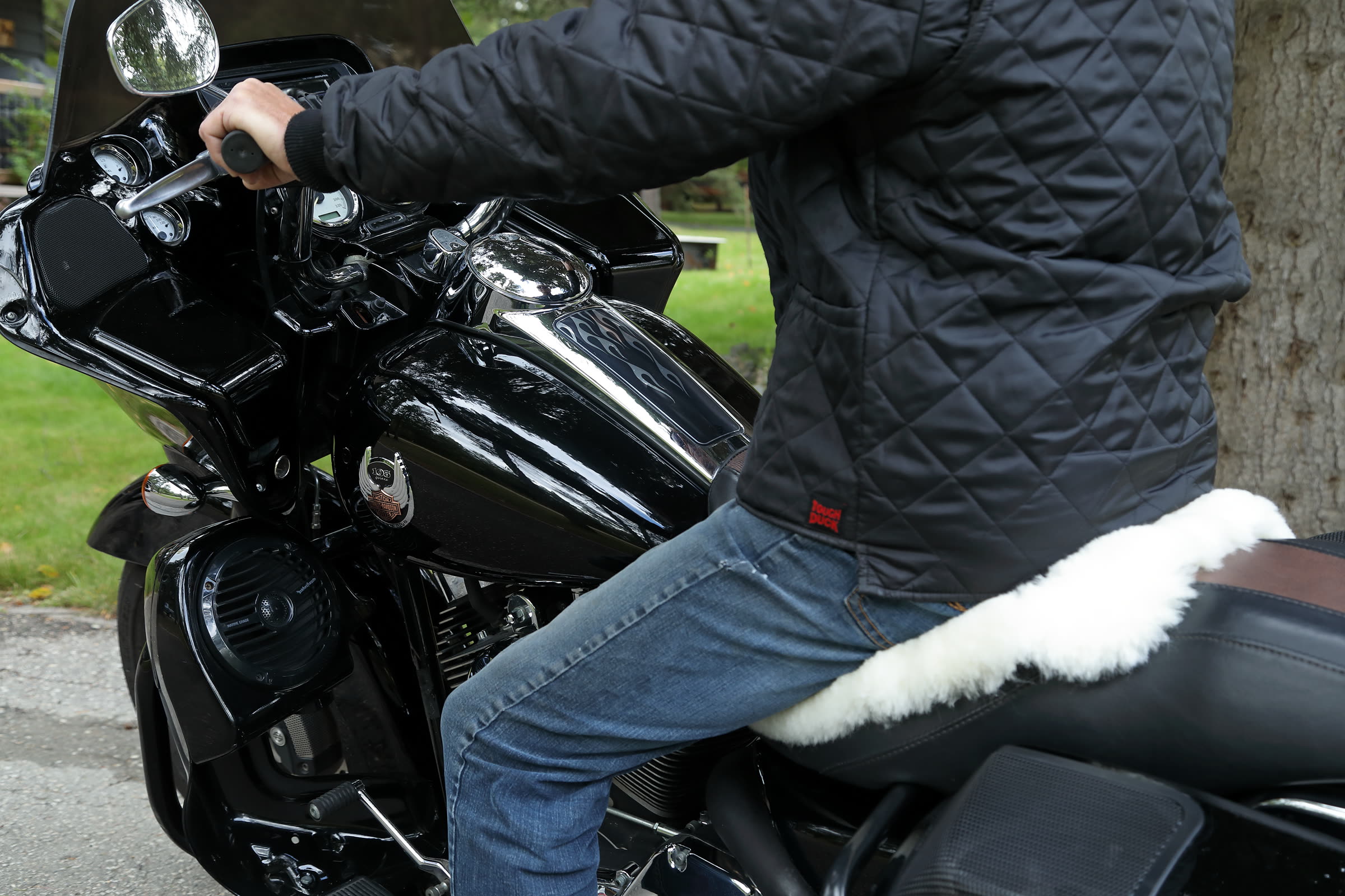 Rider on a motorcycle with a Bumwarmer sheepskin cushion on the seat