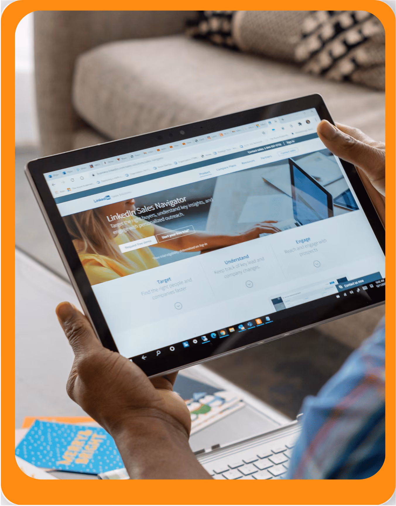 Une personne tenant une tablette affichant la page LinkedIn Sales Navigator avec des options pour cibler, comprendre et engager des prospects.
