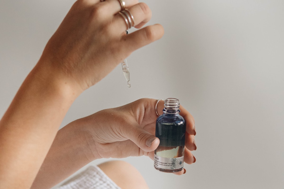 Hand holding a skincare serum bottle