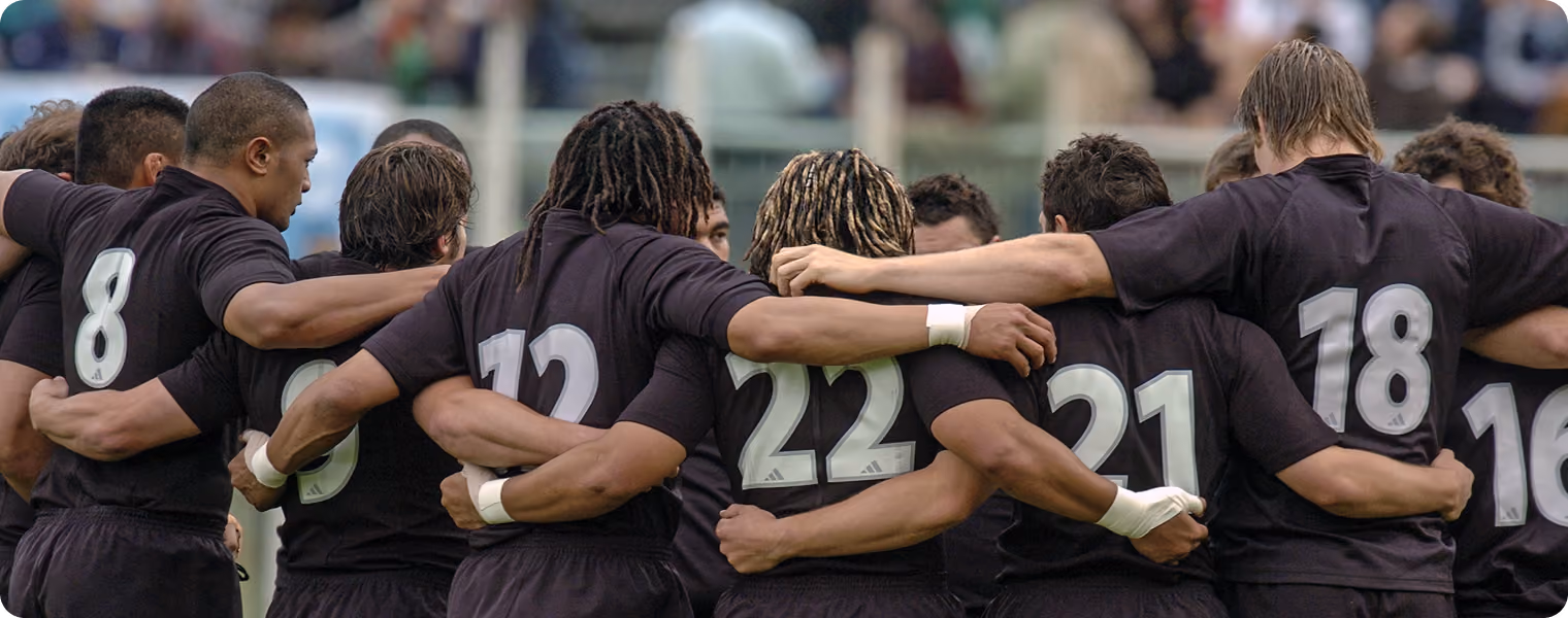 Rugbyteam van de All Blacks staat samen in een teamhuddle