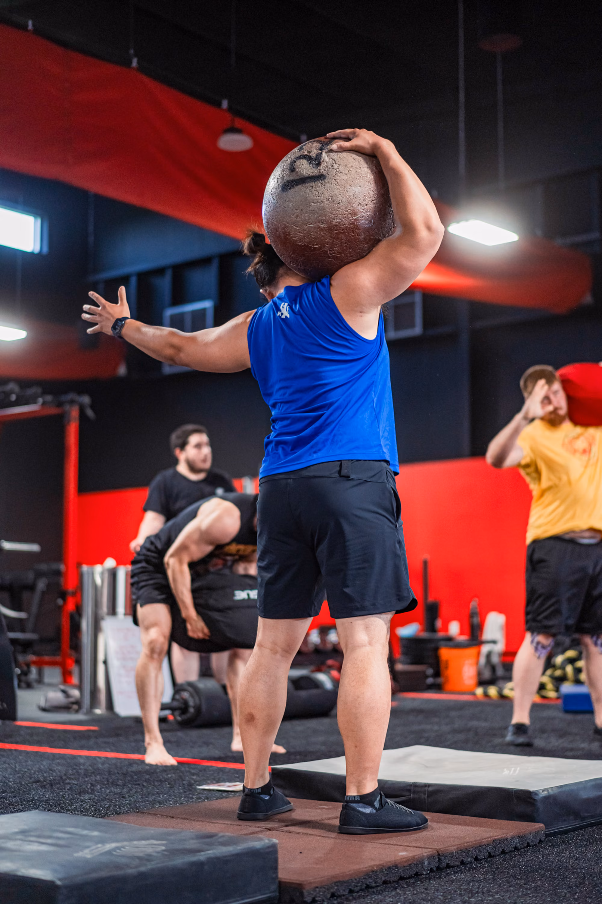 Man performing overhead med ball throw at Kinitro Fitness.