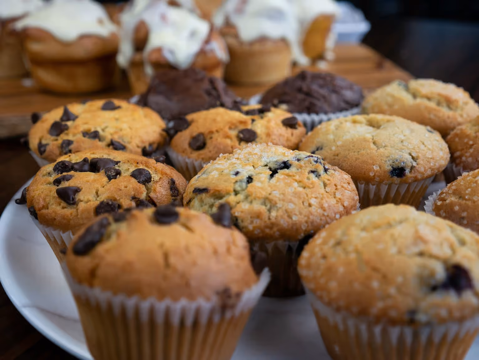Plate with assorted muffins including chocolate chip, blueberry, and chocolate varieties.