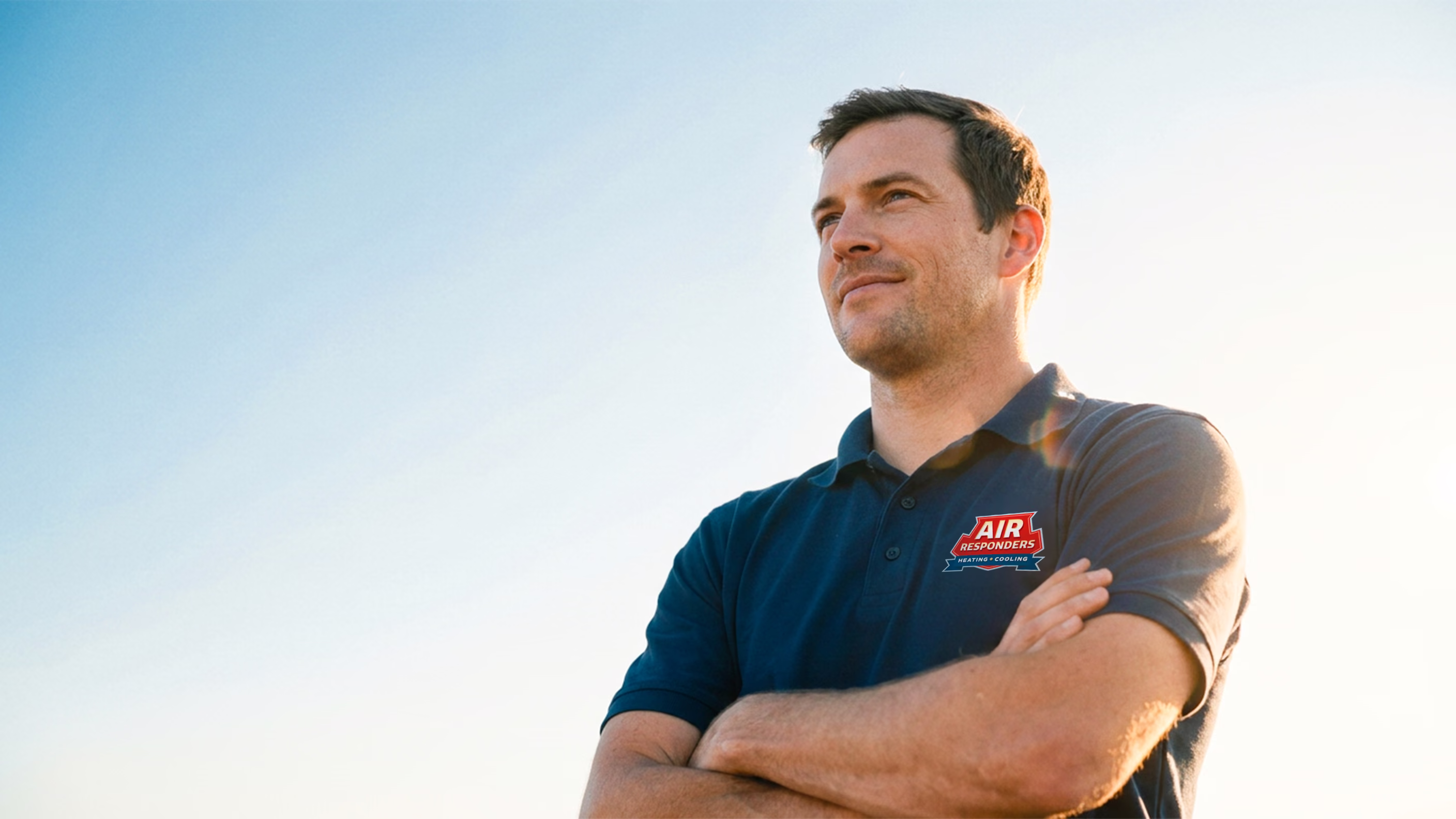 Air Responders HVAC technician in a branded navy polo standing with arms crossed