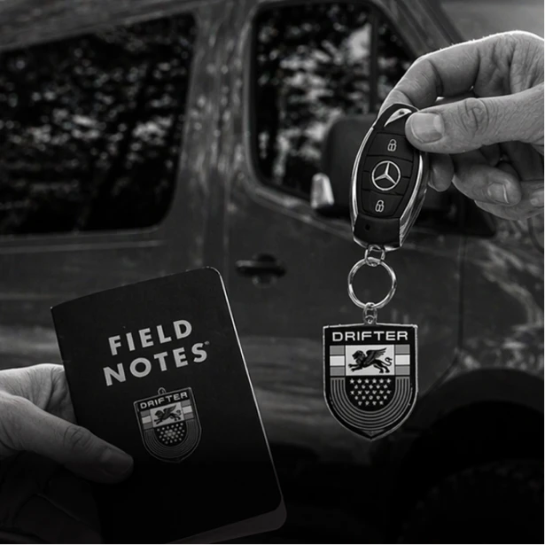 Mercedes-Benz key with a Drifter crest keychain and Field Notes notebook at van delivery
