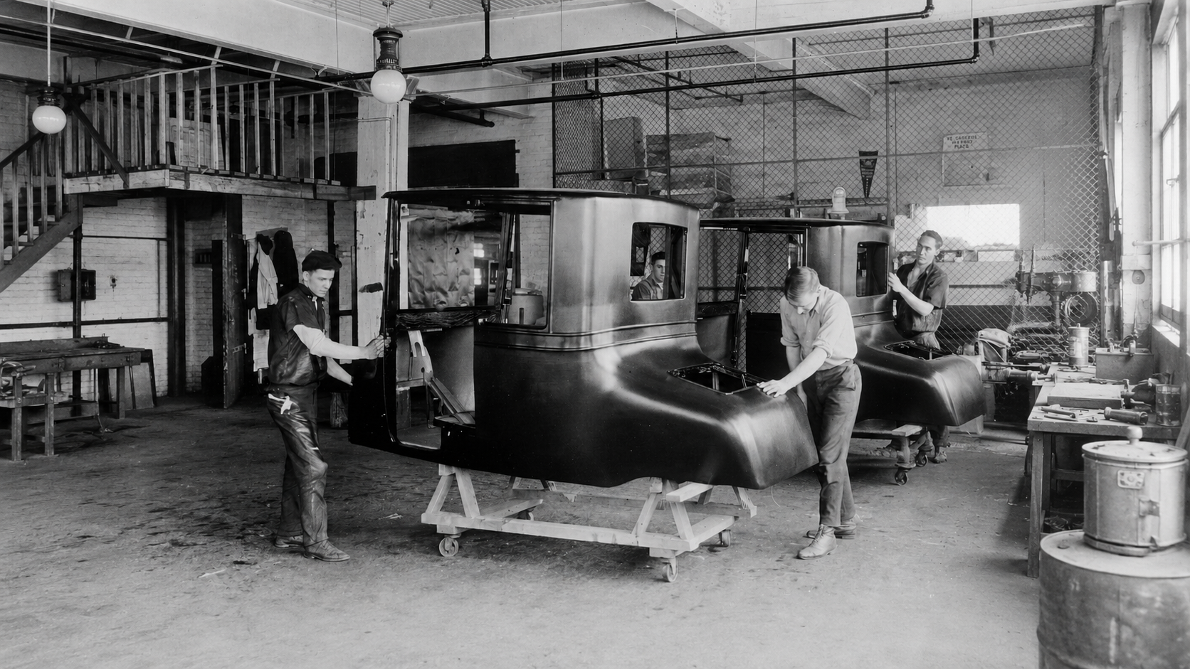 Craftsmen moving a coachbuilt car body in a Fisher Body shop, Michigan