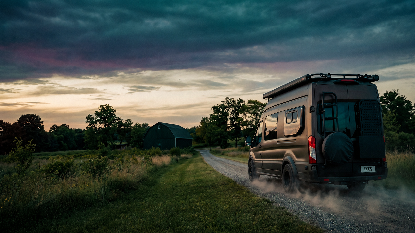 Drifter campervan on a gravel country road at dusk, barn ahead