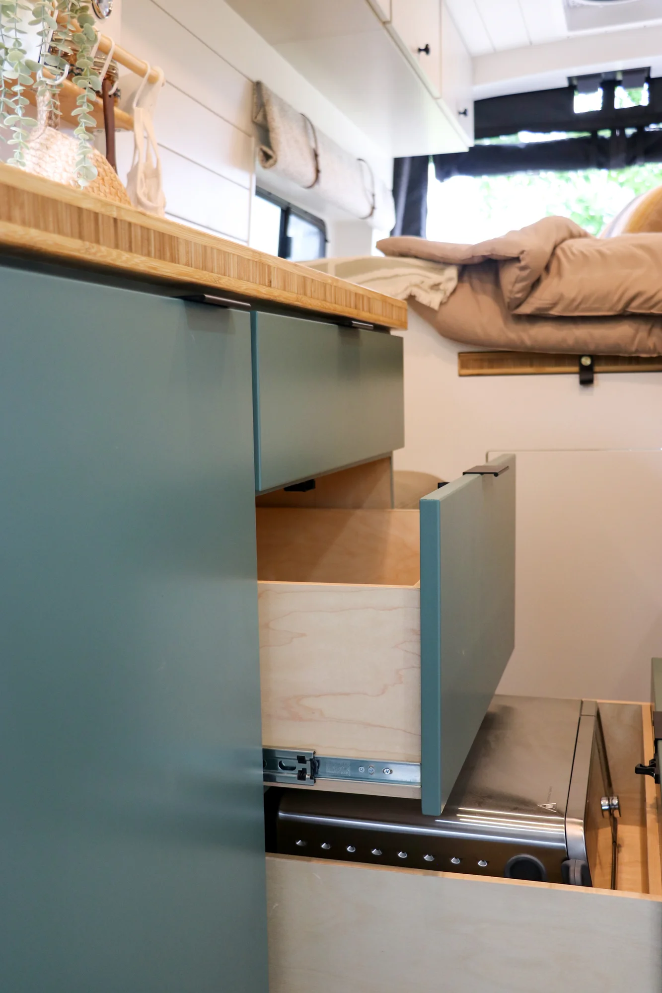 The Drifter 101 custom Ford Transit campervan built for Mallory and Matt by Drifter Vans, Nomadik layout with a bamboo countertop, matte black fixtures, marble shower, and Abyss Grey exterior
