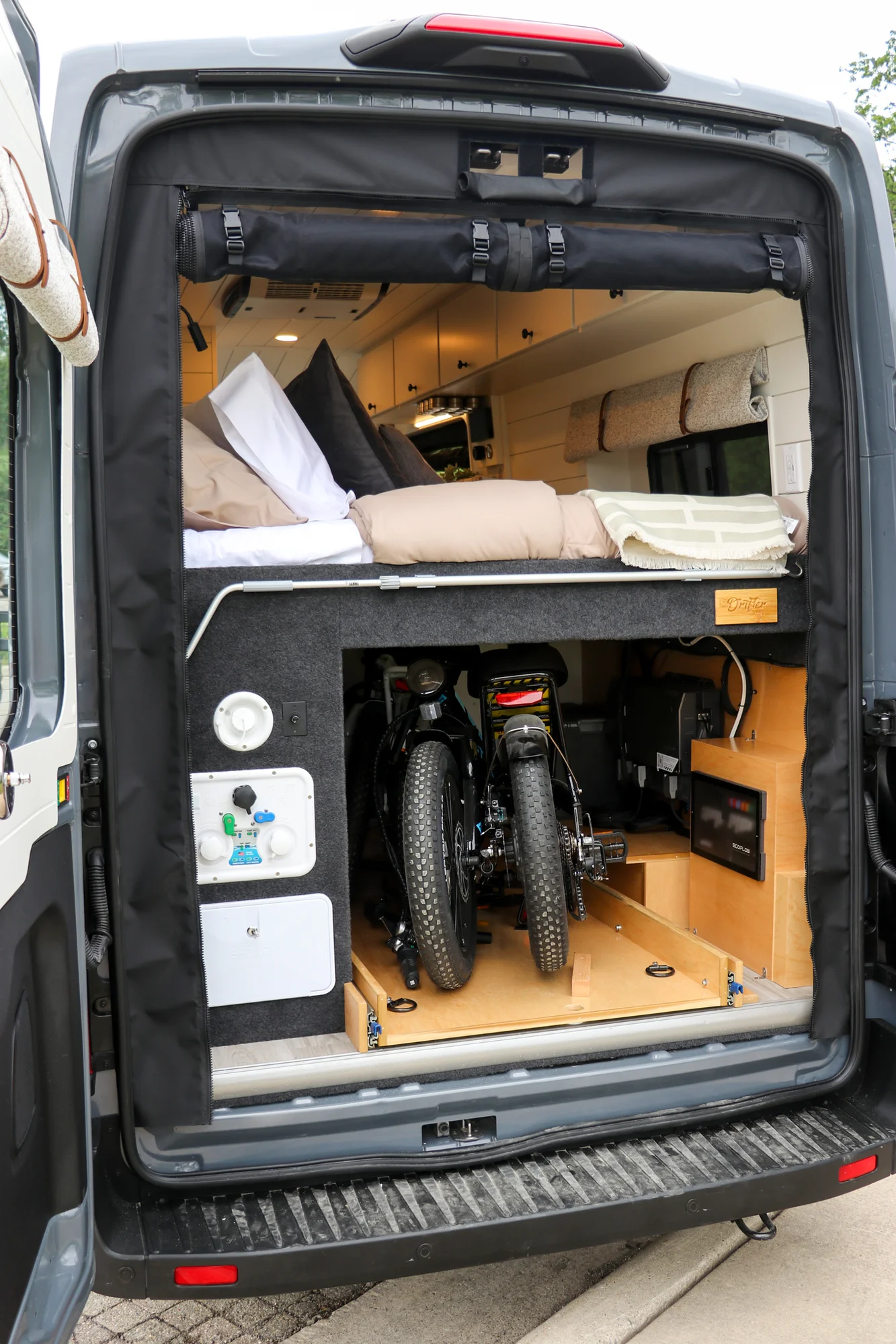 The Drifter 101 custom Ford Transit campervan built for Mallory and Matt by Drifter Vans, Nomadik layout with a bamboo countertop, matte black fixtures, marble shower, and Abyss Grey exterior