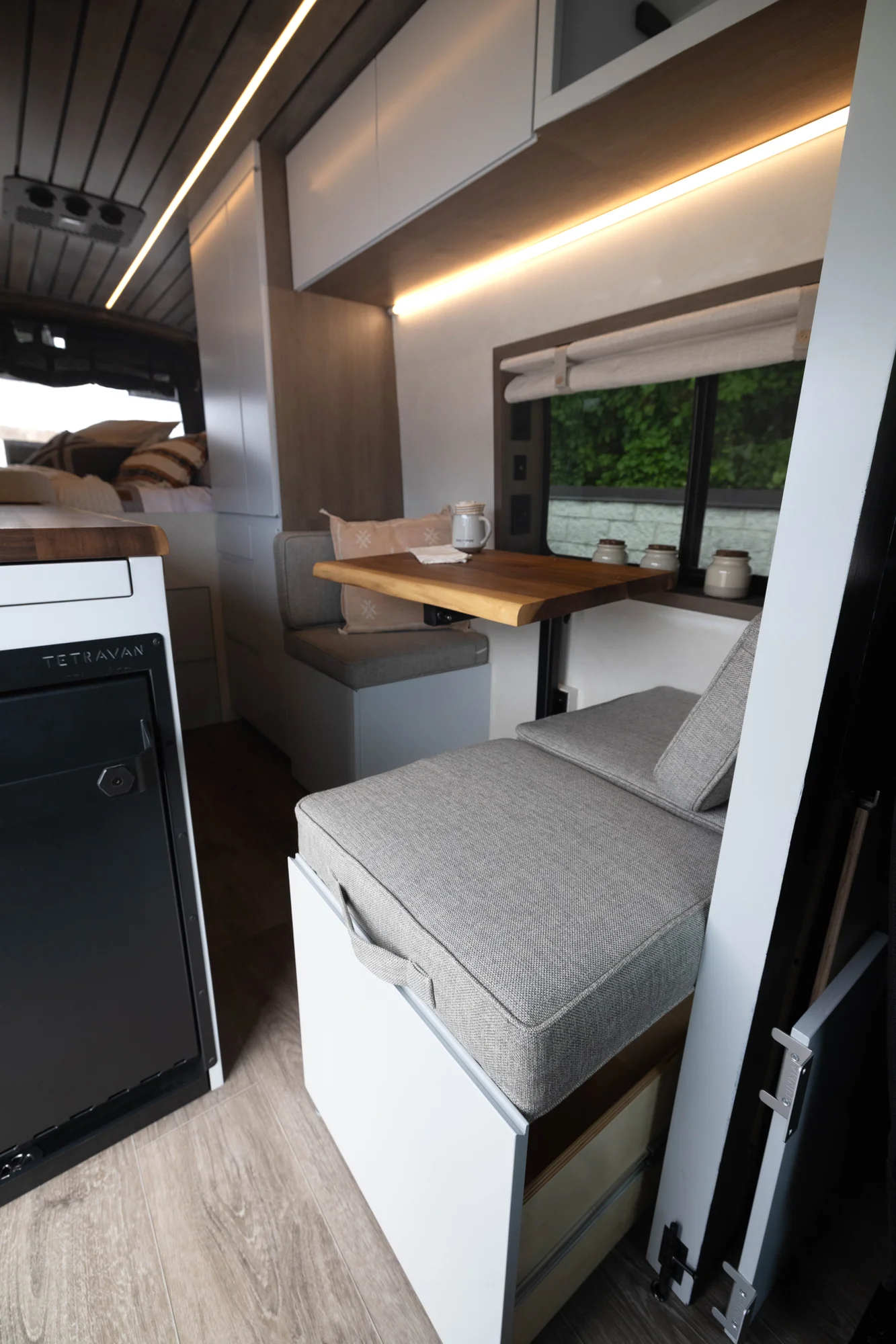 The Drifter 101 custom Ford Transit campervan built for Aron and Jamie by Drifter Vans, with GEM limewash walls, walnut countertop, an electric standing desk, and dual remote work stations