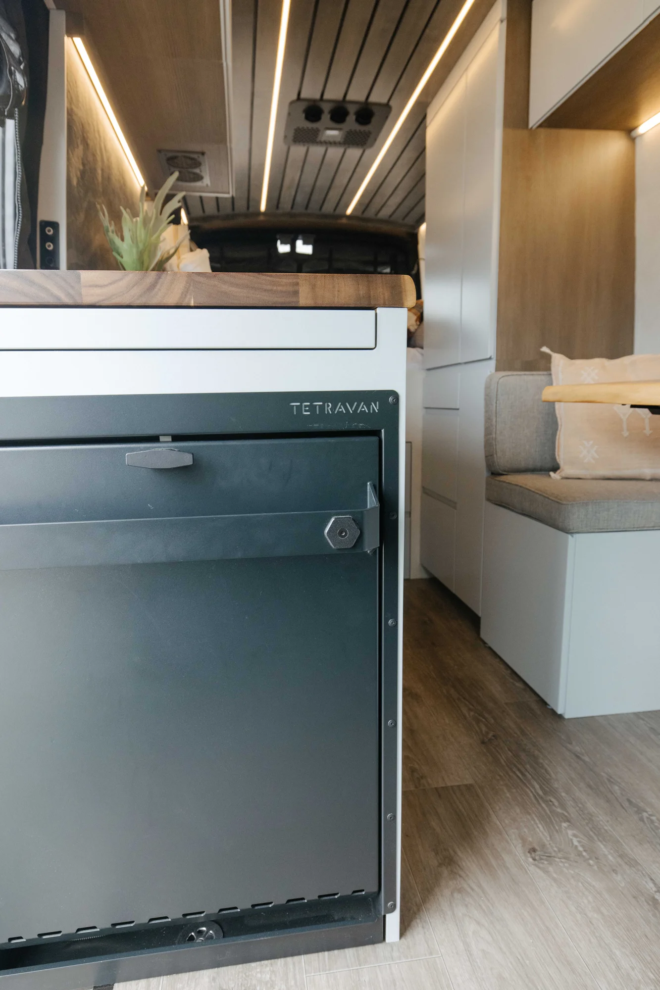 The Drifter 101 custom Ford Transit campervan built for Aron and Jamie by Drifter Vans, with GEM limewash walls, walnut countertop, an electric standing desk, and dual remote work stations