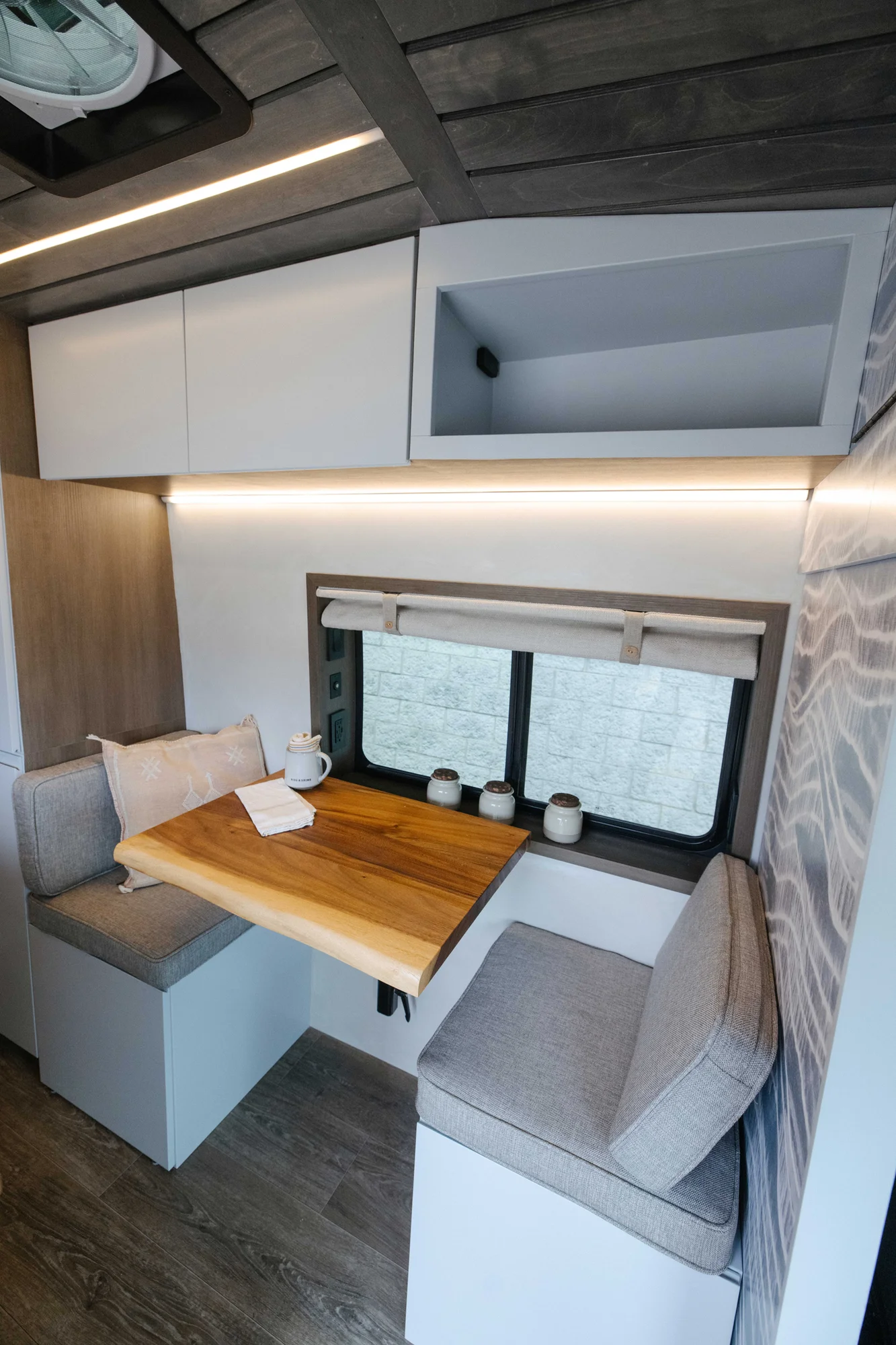 The Drifter 101 custom Ford Transit campervan built for Aron and Jamie by Drifter Vans, with GEM limewash walls, walnut countertop, an electric standing desk, and dual remote work stations