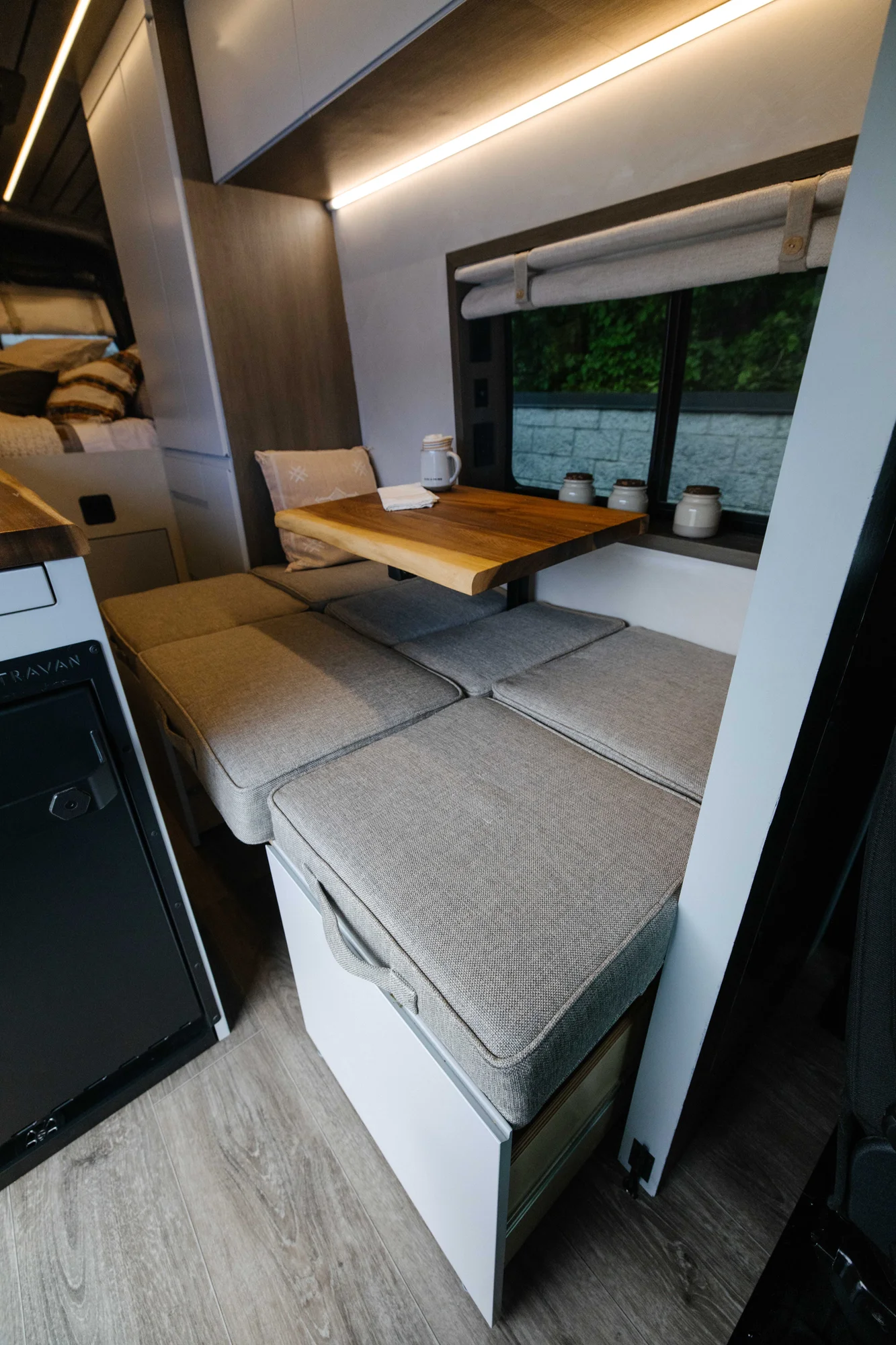 The Drifter 101 custom Ford Transit campervan built for Aron and Jamie by Drifter Vans, with GEM limewash walls, walnut countertop, an electric standing desk, and dual remote work stations