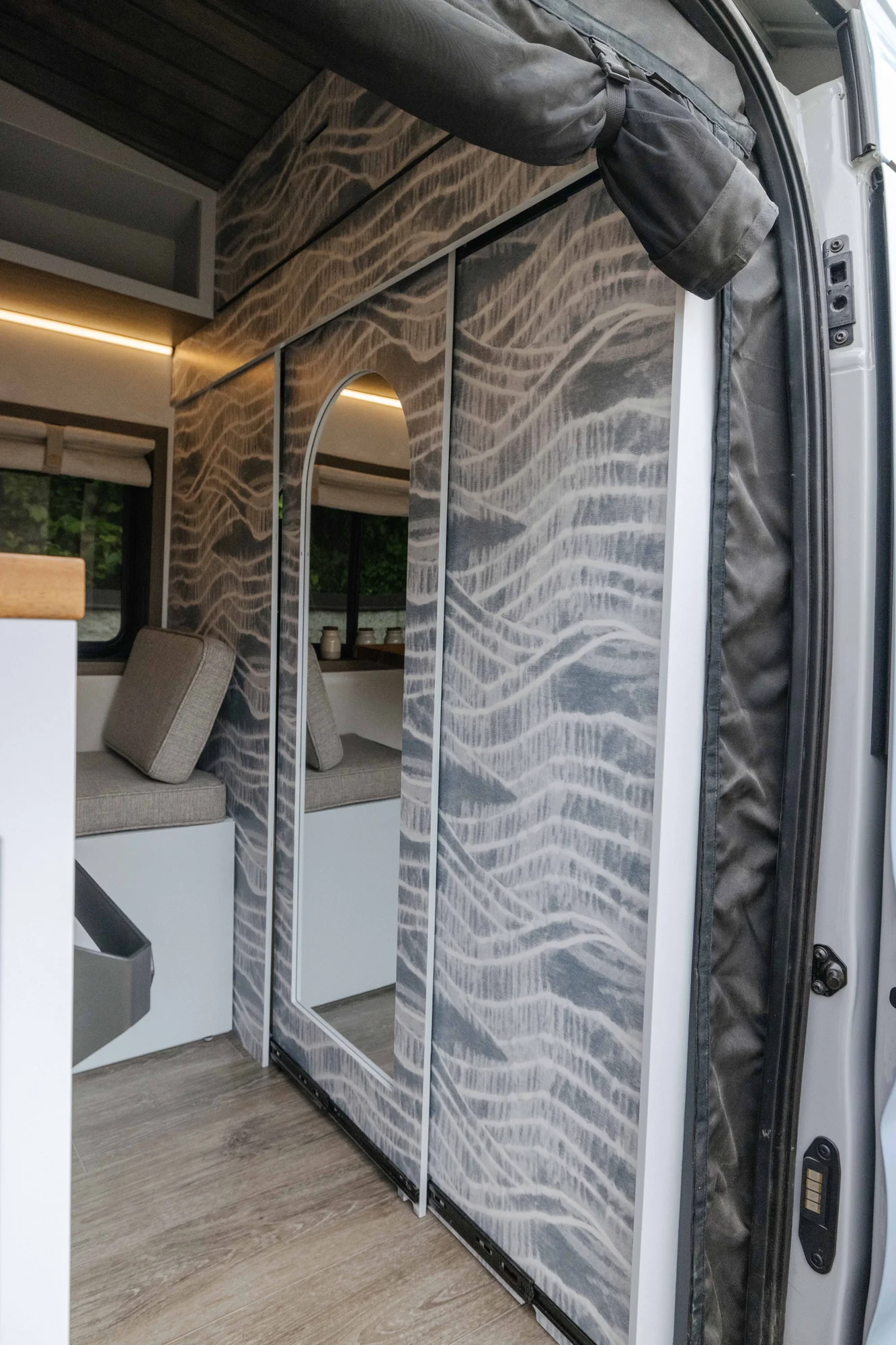 The Drifter 101 custom Ford Transit campervan built for Aron and Jamie by Drifter Vans, with GEM limewash walls, walnut countertop, an electric standing desk, and dual remote work stations