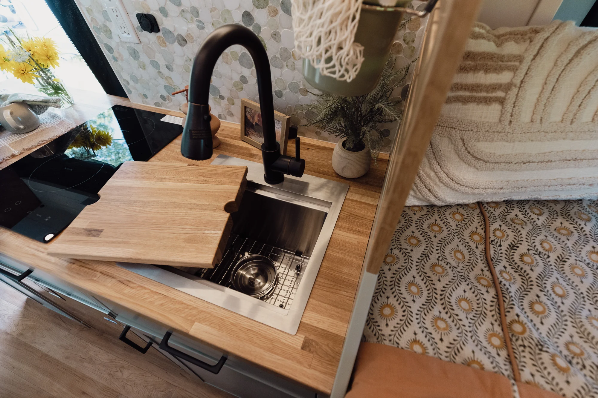 The Drifter 101 custom Ford Transit campervan built for Judy by Drifter Vans, Drifter layout with a boho interior, white oak butcher block, Honey Onix tile backsplash, and Avalanche Grey exterior
