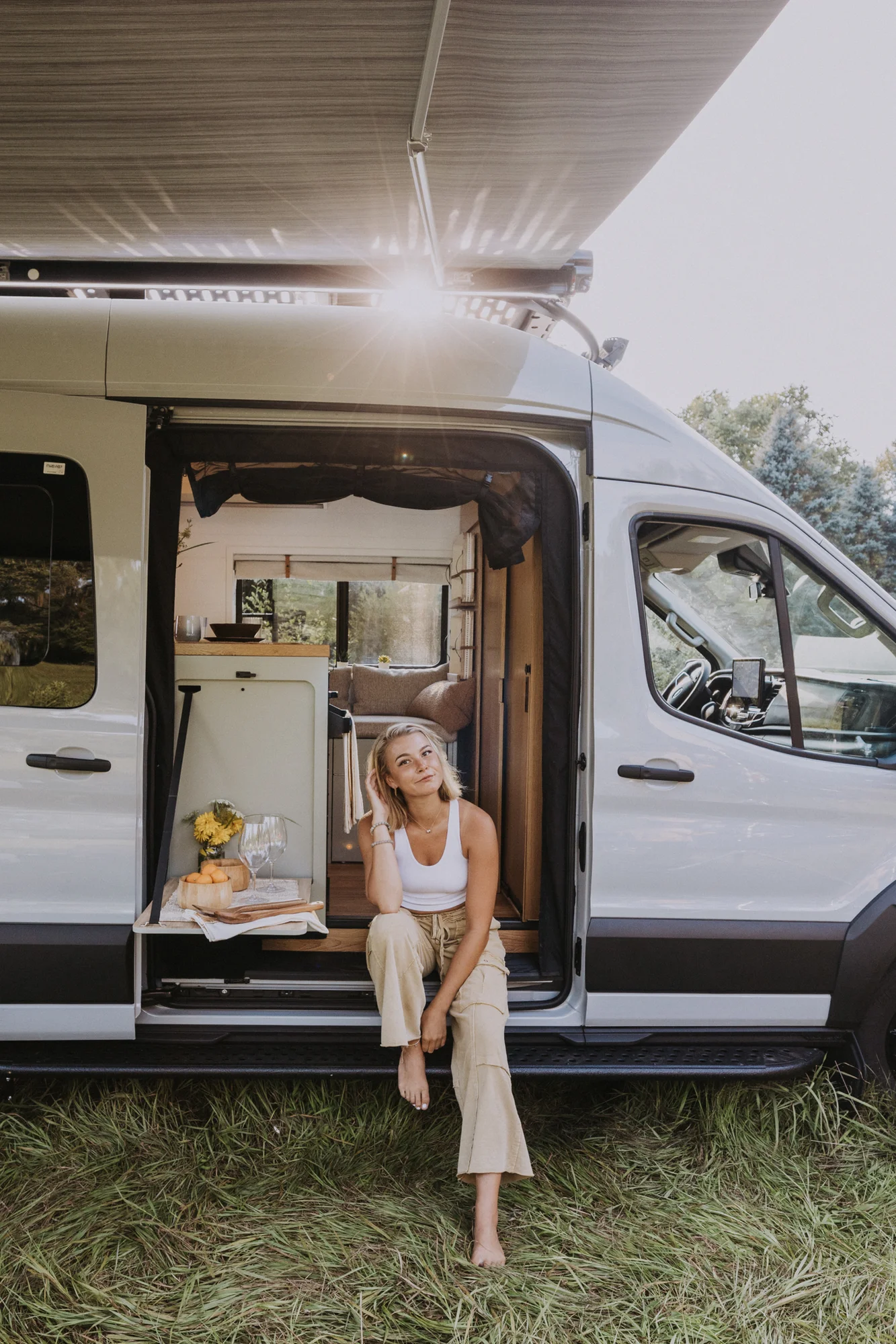 The Drifter 101 custom Ford Transit campervan built for Judy by Drifter Vans, Drifter layout with a boho interior, white oak butcher block, Honey Onix tile backsplash, and Avalanche Grey exterior