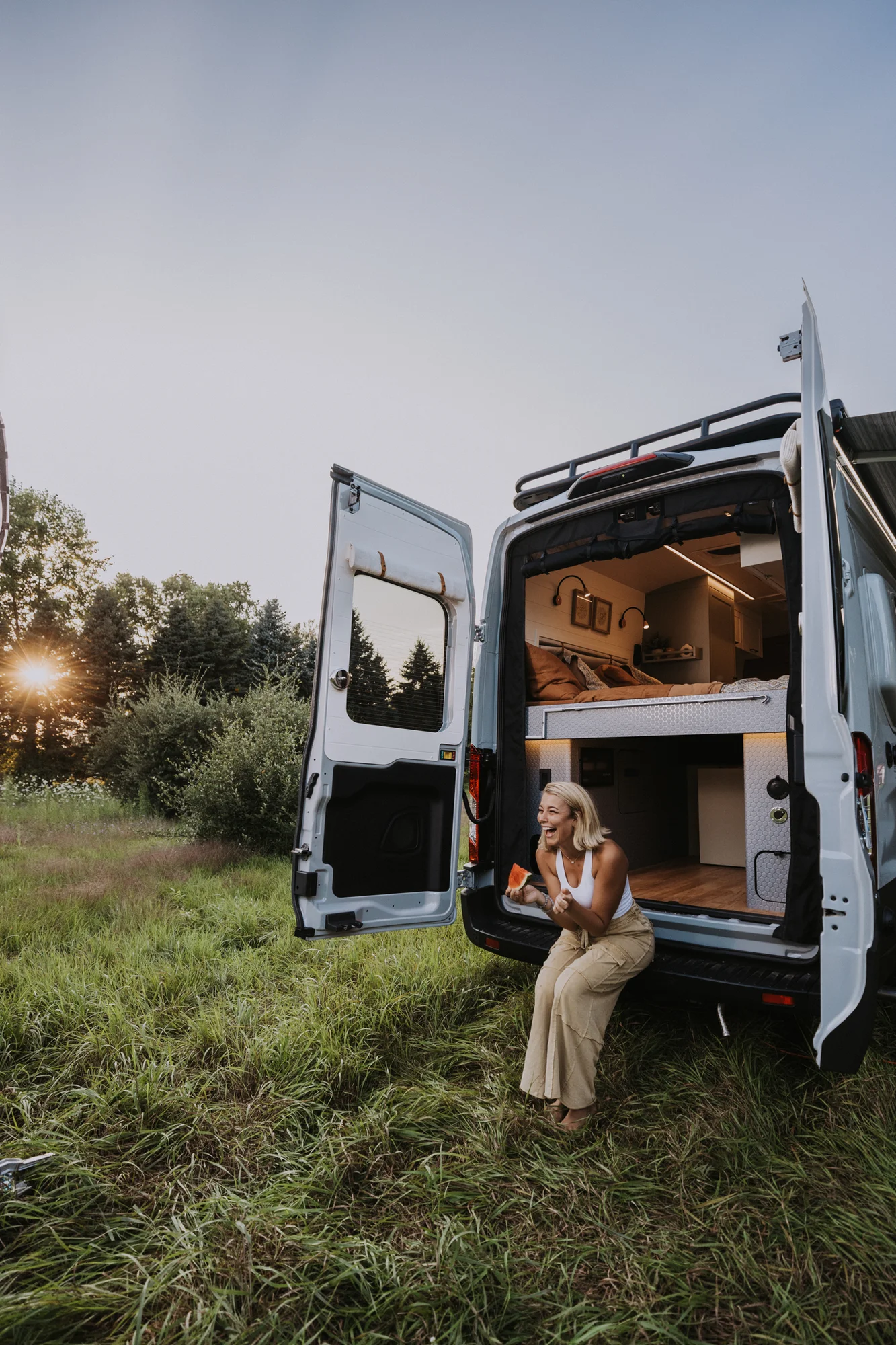 The Drifter 101 custom Ford Transit campervan built for Judy by Drifter Vans, Drifter layout with a boho interior, white oak butcher block, Honey Onix tile backsplash, and Avalanche Grey exterior