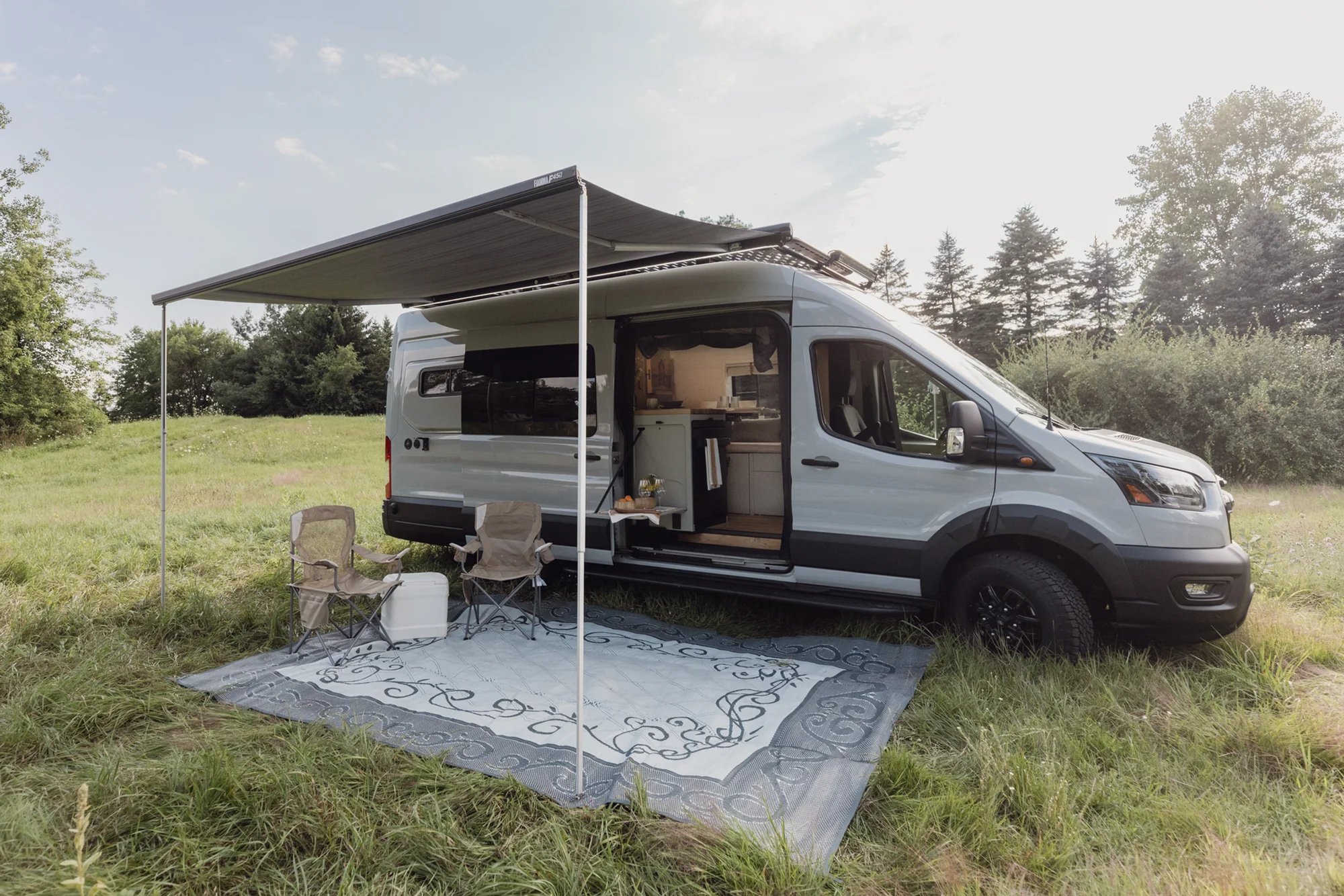 The Drifter 101 custom Ford Transit campervan built for Judy by Drifter Vans, Drifter layout with a boho interior, white oak butcher block, Honey Onix tile backsplash, and Avalanche Grey exterior