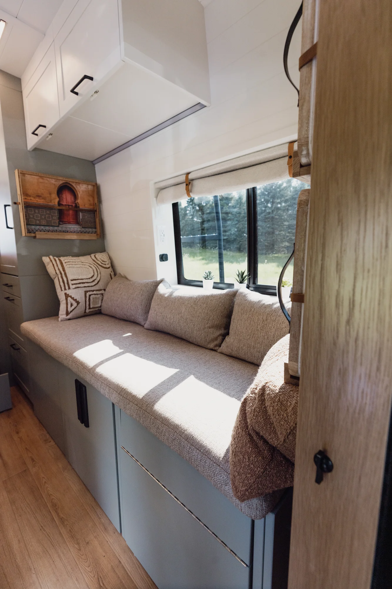 The Drifter 101 custom Ford Transit campervan built for Judy by Drifter Vans, Drifter layout with a boho interior, white oak butcher block, Honey Onix tile backsplash, and Avalanche Grey exterior