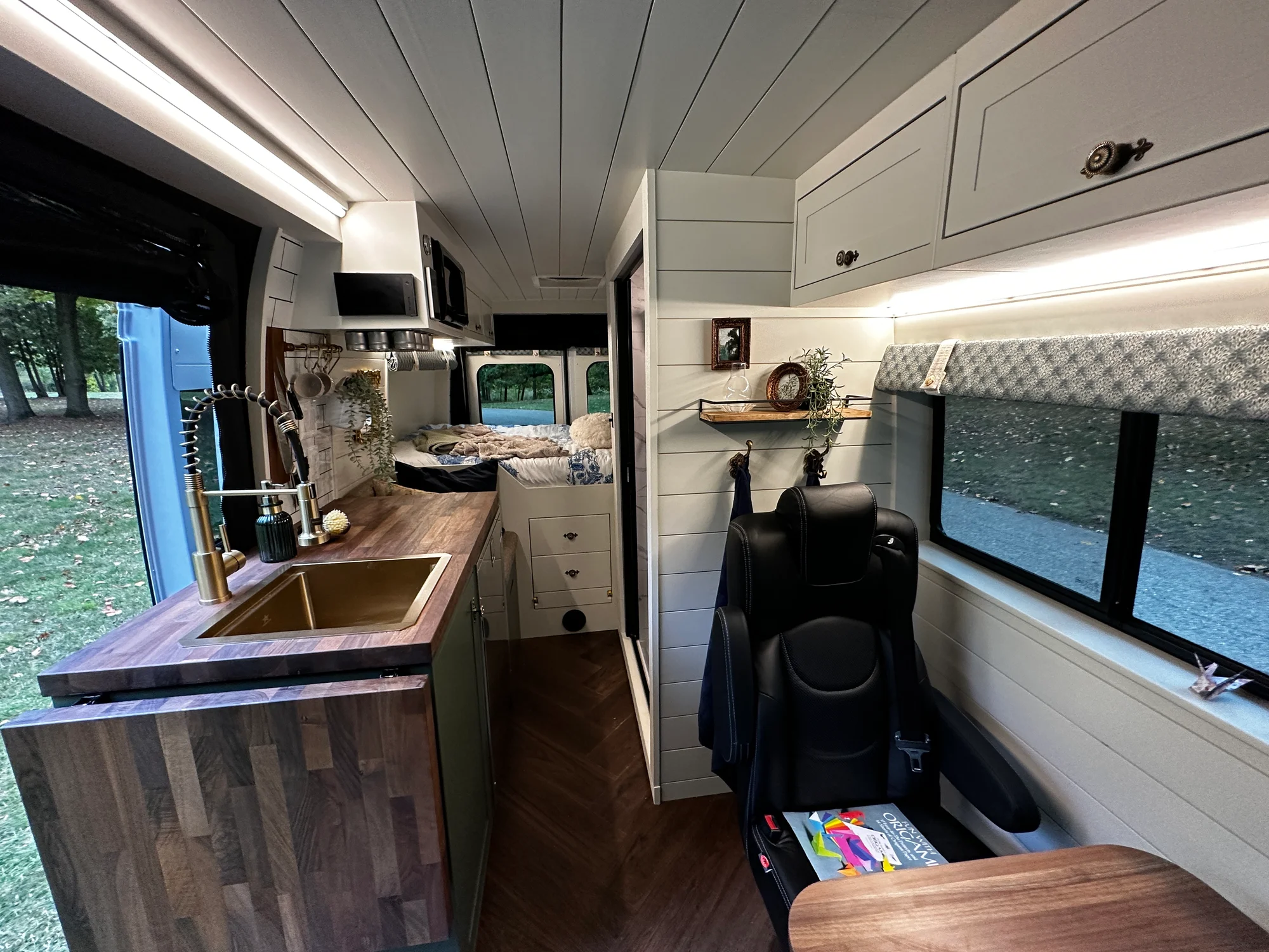 The Drifter 101 custom Ford Transit campervan built for Olivia by Drifter Vans, with a brass sink, walnut countertop, marble shower, and shiplap walls