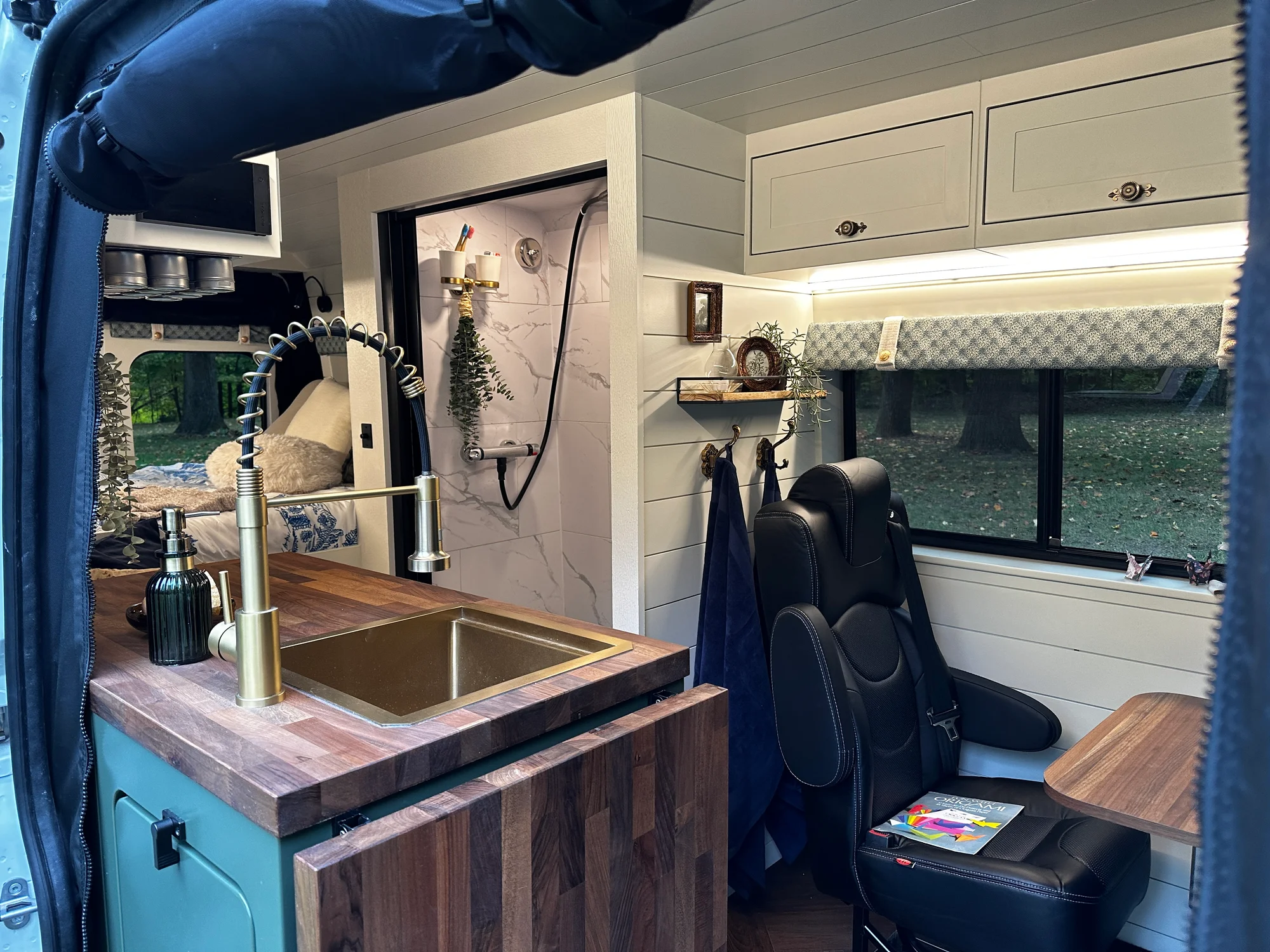 The Drifter 101 custom Ford Transit campervan built for Olivia by Drifter Vans, with a brass sink, walnut countertop, marble shower, and shiplap walls