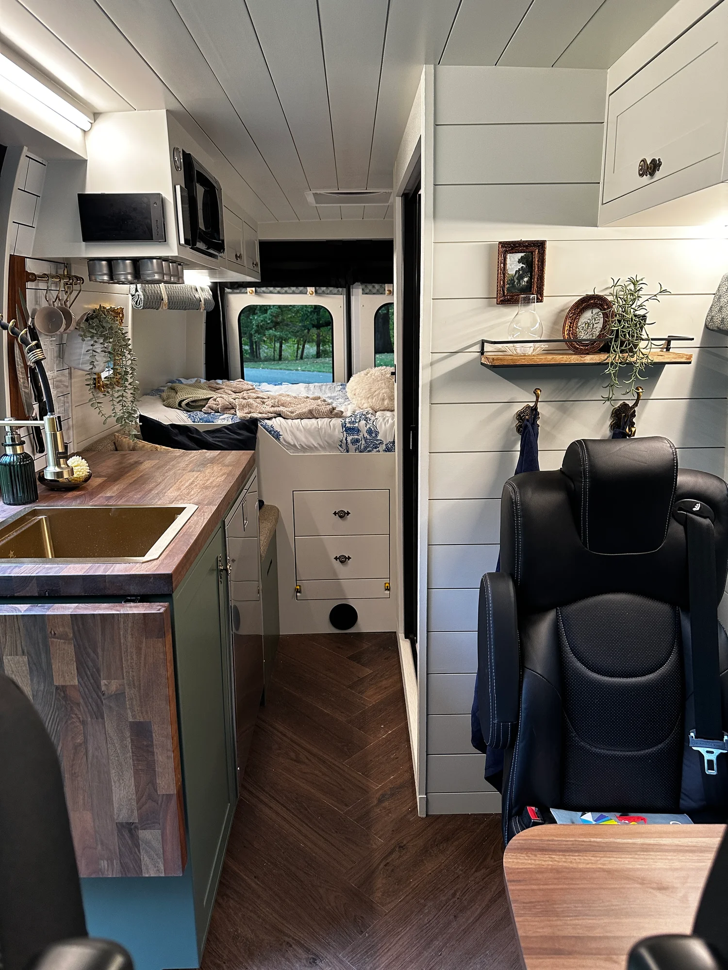 The Drifter 101 custom Ford Transit campervan built for Olivia by Drifter Vans, with a brass sink, walnut countertop, marble shower, and shiplap walls