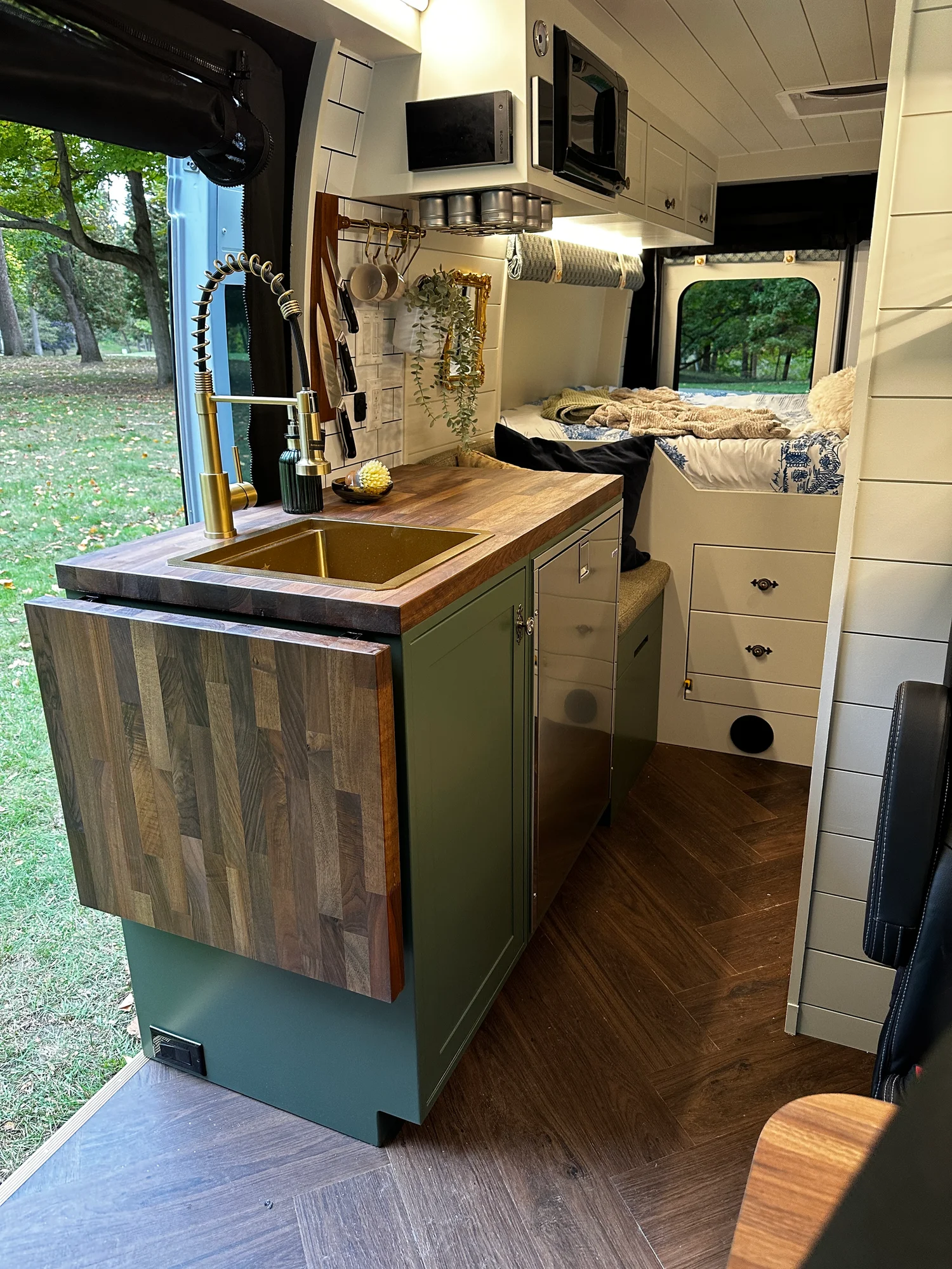The Drifter 101 custom Ford Transit campervan built for Olivia by Drifter Vans, with a brass sink, walnut countertop, marble shower, and shiplap walls