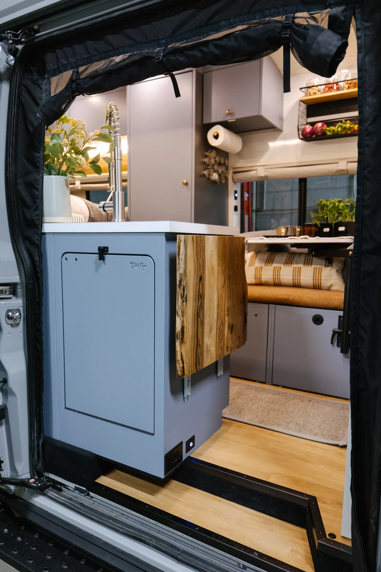 The Drifter 101 custom Ford Transit campervan built for Derek by Drifter Vans, Wanderer layout with a rear Overland Kitchen, knotty pine walls, and grey cabinetry