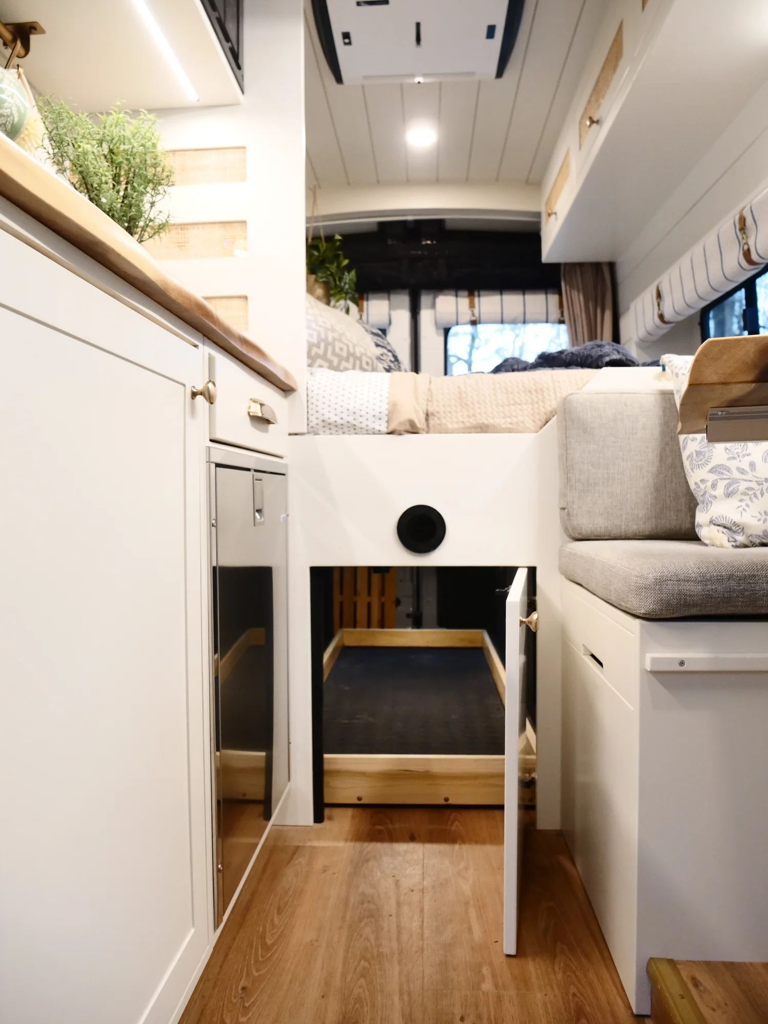 The Drifter 101 custom Ford Transit campervan built for Lori by Drifter Vans, Wanderer layout with a modern farmhouse interior, maple butcher block countertop, gold fixtures, and an exterior FVCO roof rack and ladder