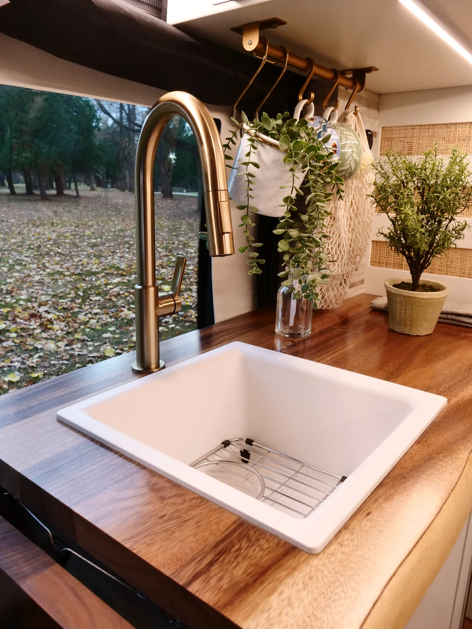 The Drifter 101 custom Ford Transit campervan built for Lori by Drifter Vans, Wanderer layout with a modern farmhouse interior, maple butcher block countertop, gold fixtures, and an exterior FVCO roof rack and ladder