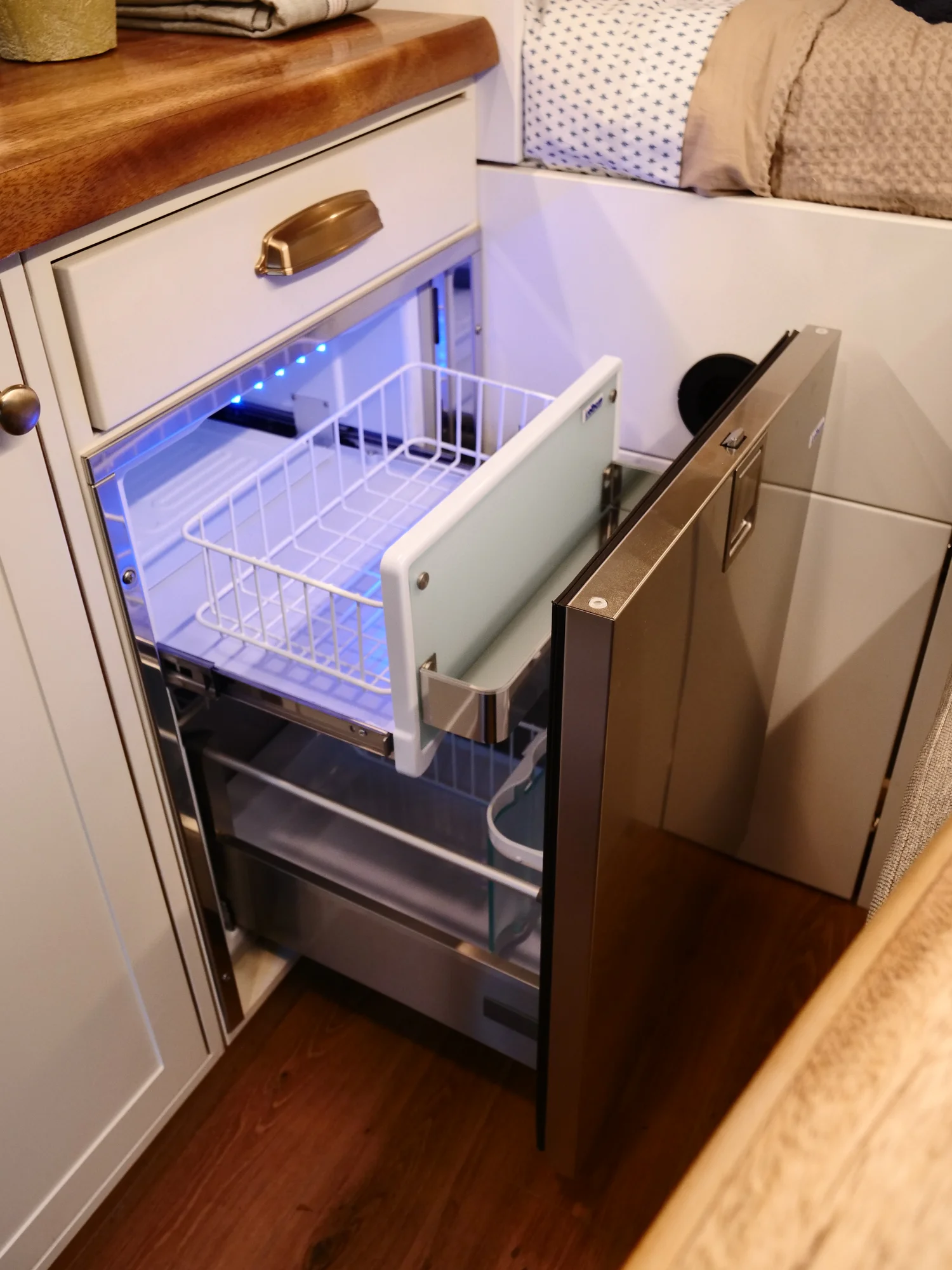 The Drifter 101 custom Ford Transit campervan built for Lori by Drifter Vans, Wanderer layout with a modern farmhouse interior, maple butcher block countertop, gold fixtures, and an exterior FVCO roof rack and ladder