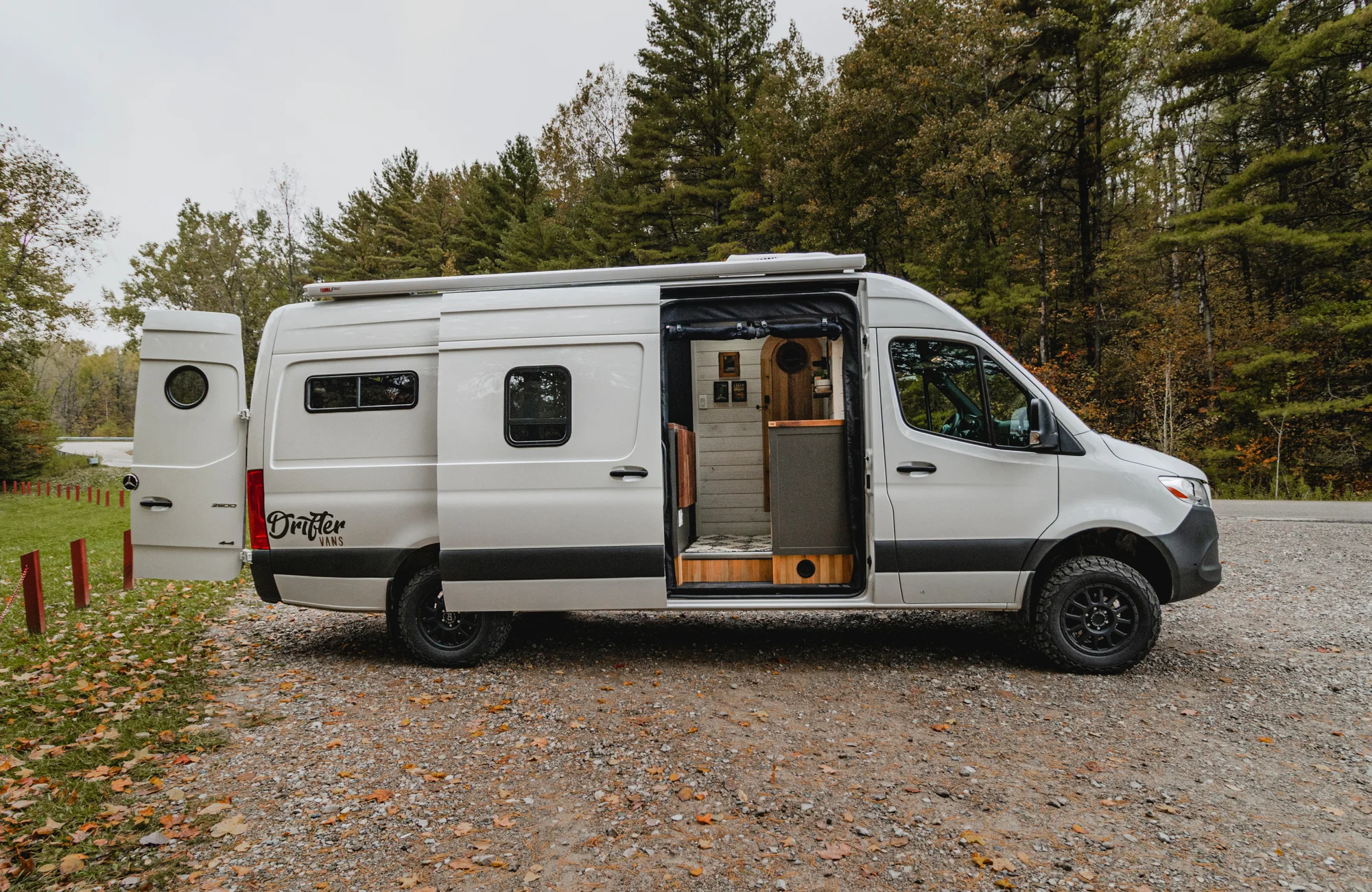 The Drifter 101 custom Mercedes-Benz Sprinter campervan built for Roger and Melisa by Drifter Vans, with a porthole wood shower door, dark wood interior, Southwest-style backsplash, and cast iron hardware