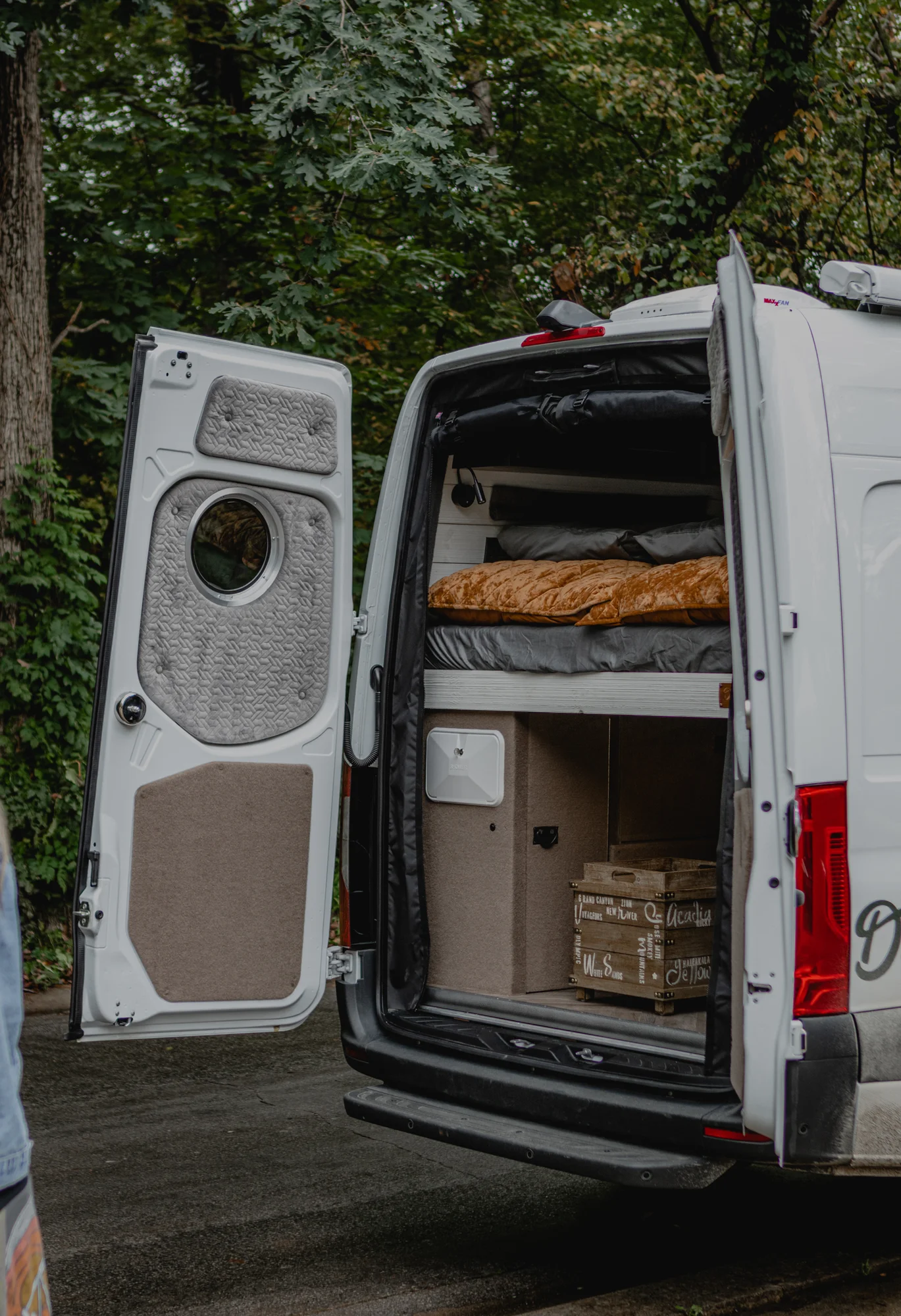 The Drifter 101 custom Mercedes-Benz Sprinter campervan built for Roger and Melisa by Drifter Vans, with a porthole wood shower door, dark wood interior, Southwest-style backsplash, and cast iron hardware