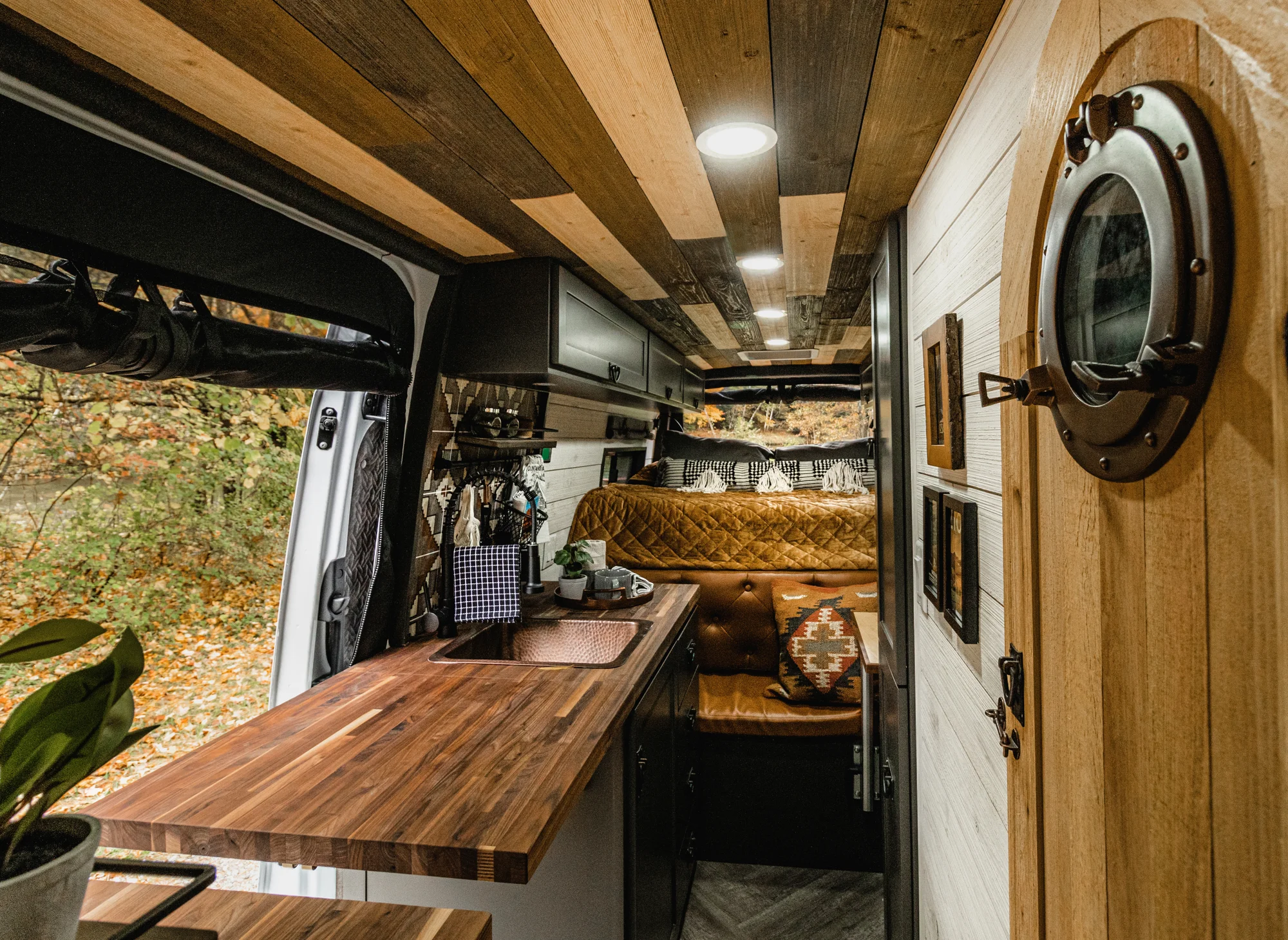 The Drifter 101 custom Mercedes-Benz Sprinter campervan built for Roger and Melisa by Drifter Vans, with a porthole wood shower door, dark wood interior, Southwest-style backsplash, and cast iron hardware