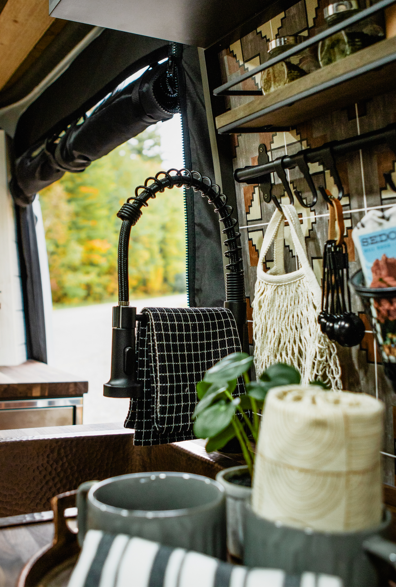 The Drifter 101 custom Mercedes-Benz Sprinter campervan built for Roger and Melisa by Drifter Vans, with a porthole wood shower door, dark wood interior, Southwest-style backsplash, and cast iron hardware