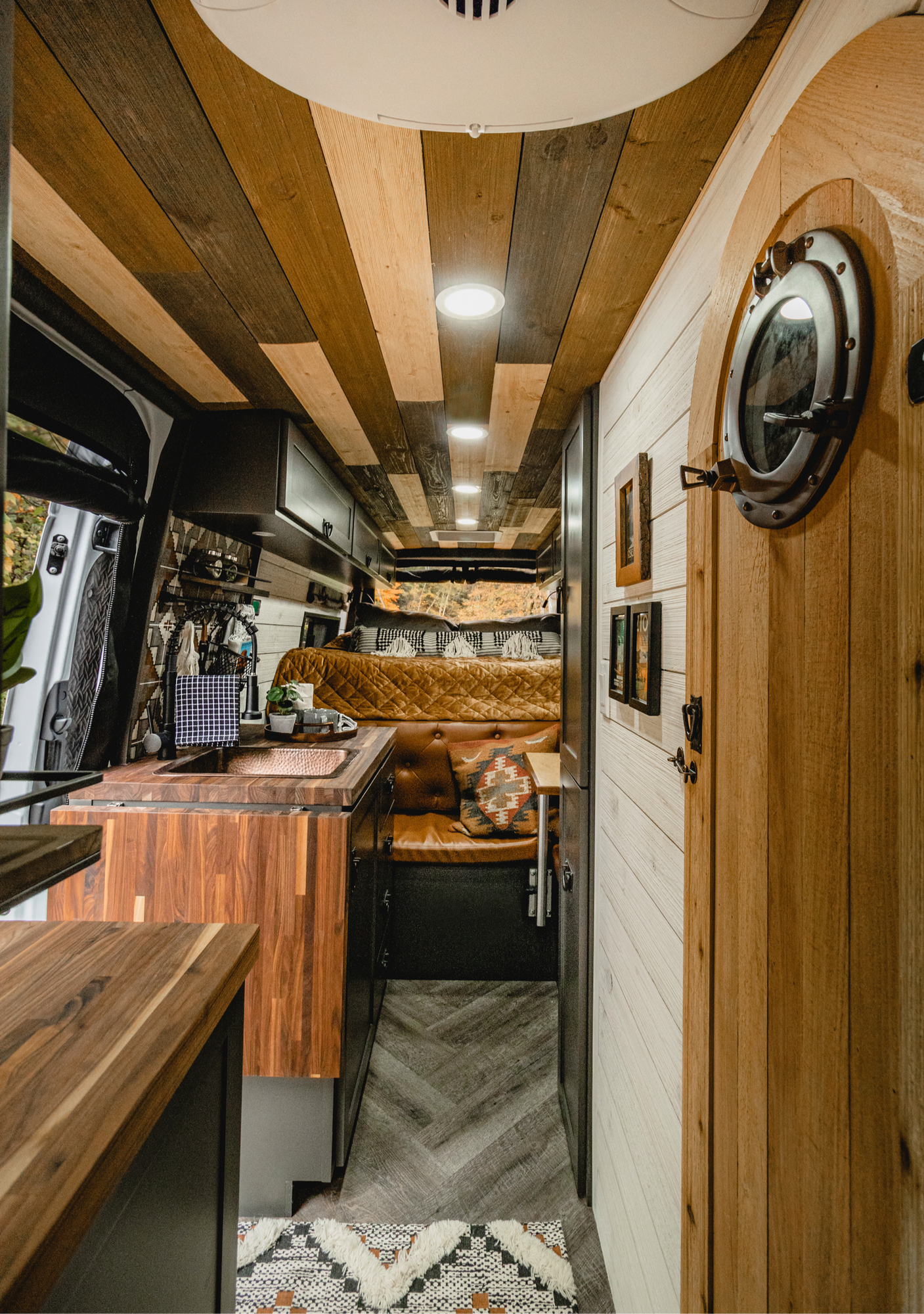 The Drifter 101 custom Mercedes-Benz Sprinter campervan built for Roger and Melisa by Drifter Vans, with a porthole wood shower door, dark wood interior, Southwest-style backsplash, and cast iron hardware