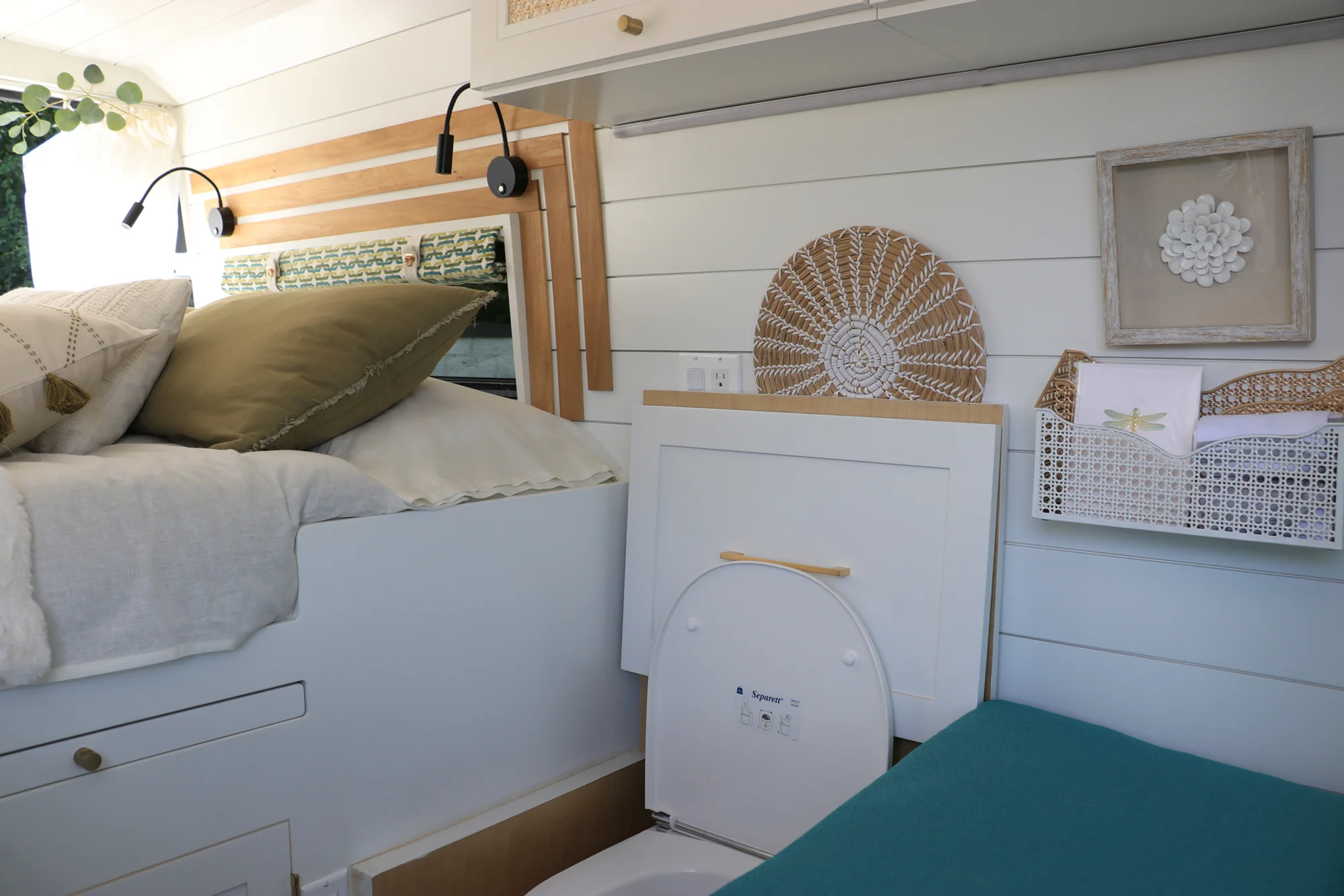 The Drifter 101 custom Ford Transit campervan built for Amy by Drifter Vans, with a natural bamboo countertop, hex tile backsplash, gold fixtures, and white cabinetry with blue accents