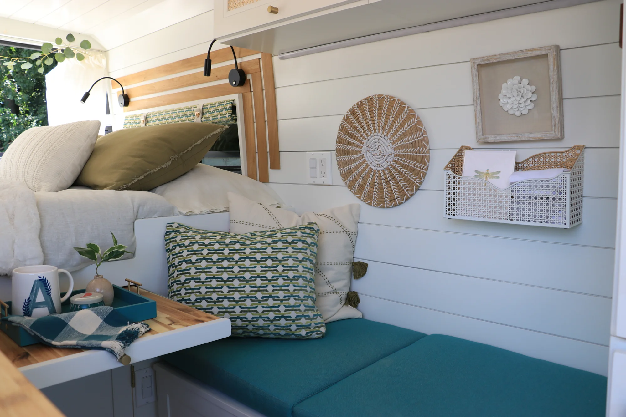 The Drifter 101 custom Ford Transit campervan built for Amy by Drifter Vans, with a natural bamboo countertop, hex tile backsplash, gold fixtures, and white cabinetry with blue accents