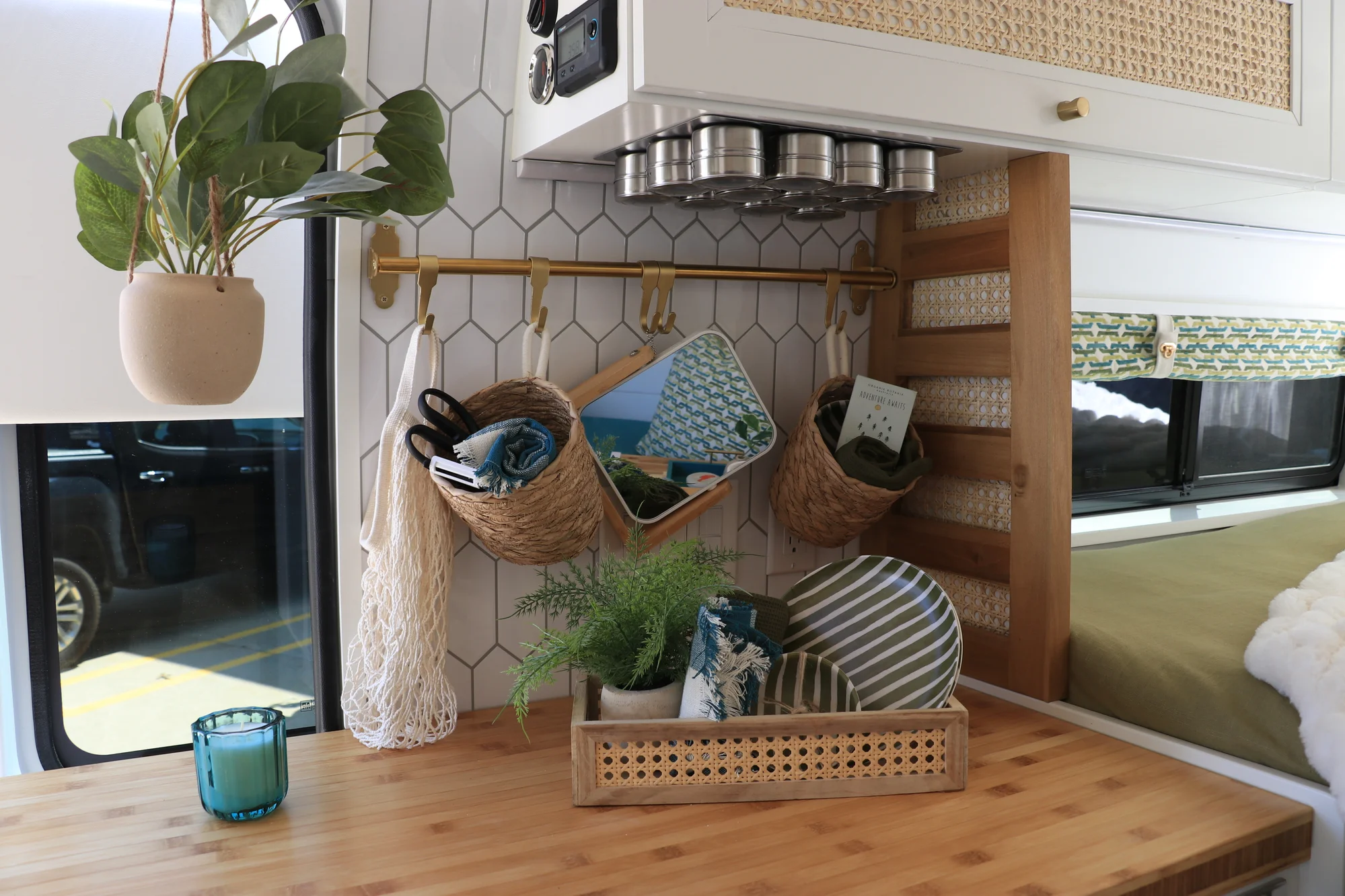 The Drifter 101 custom Ford Transit campervan built for Amy by Drifter Vans, with a natural bamboo countertop, hex tile backsplash, gold fixtures, and white cabinetry with blue accents