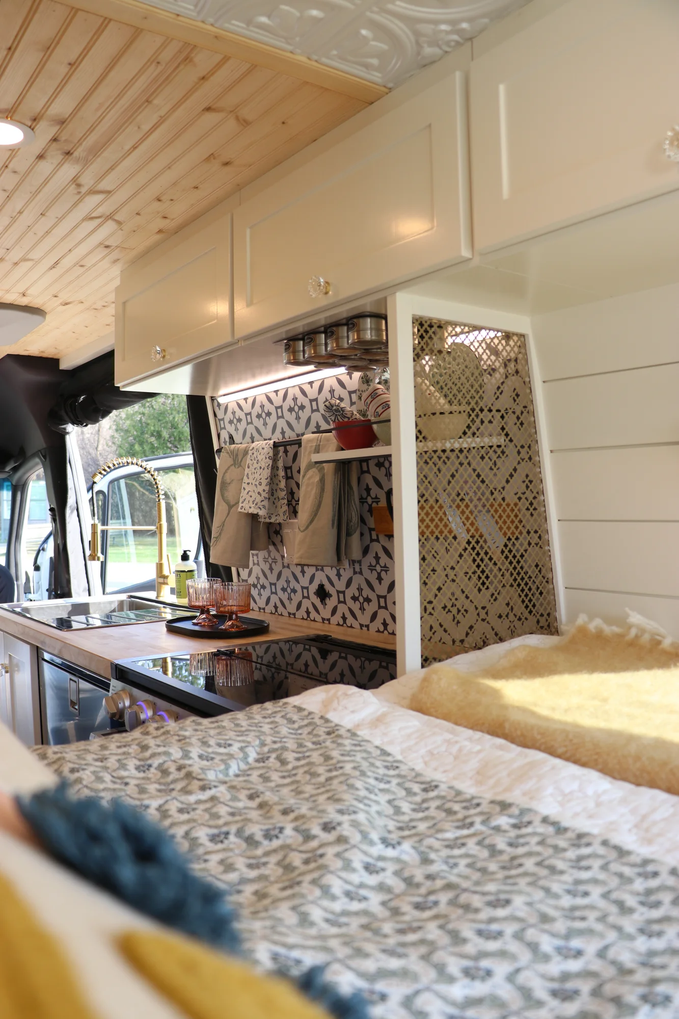 The Drifter 101 custom Mercedes-Benz Sprinter campervan built for Suzzane by Drifter Vans, with geometric patterned tile, sage green seating, white shiplap walls, and brass fixtures