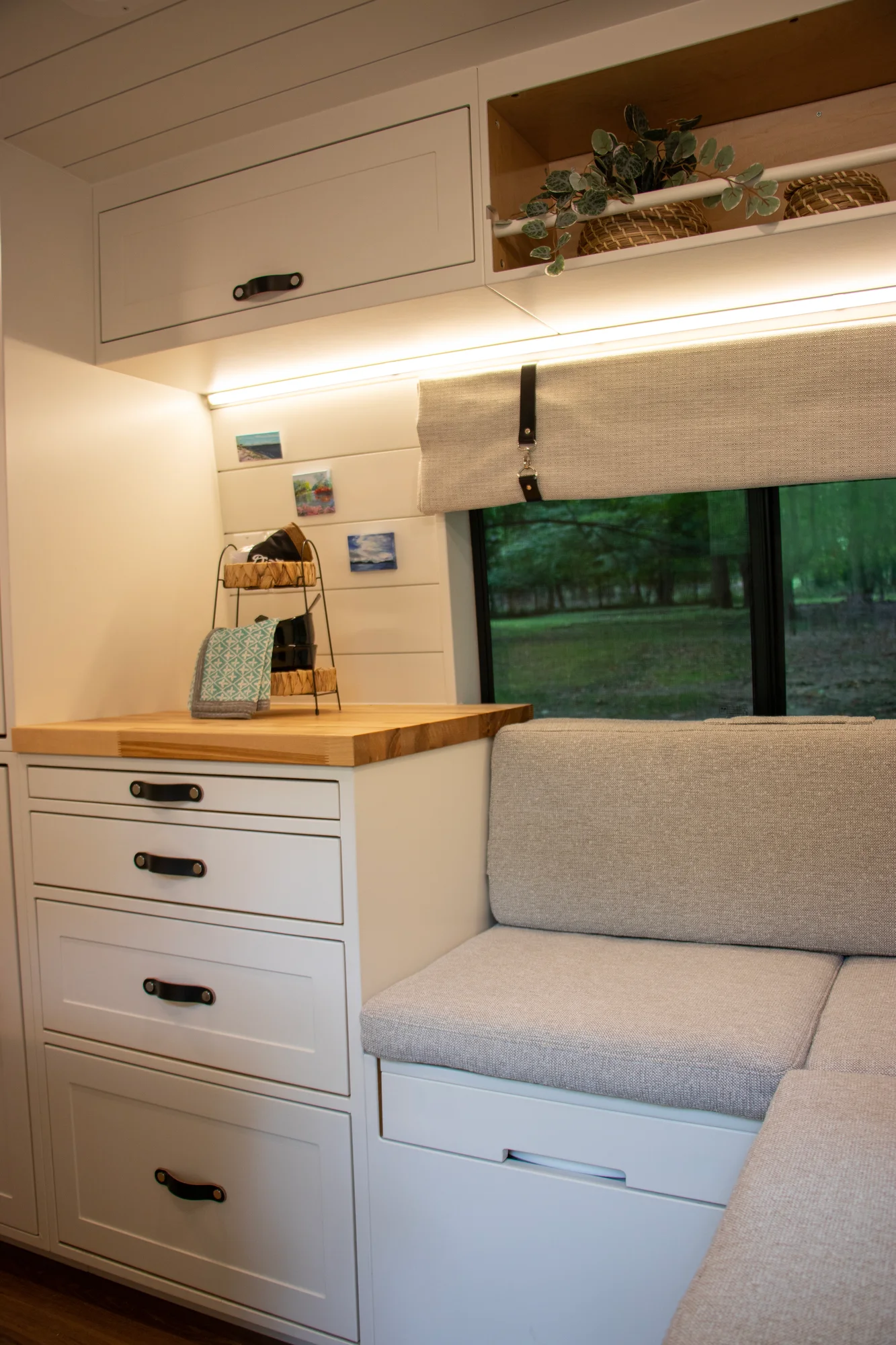 The Drifter 101 custom Ram ProMaster campervan built for Diane by Drifter Vans, with white cabinetry, butcher block countertop, a convertible bed system, and coastal accents
