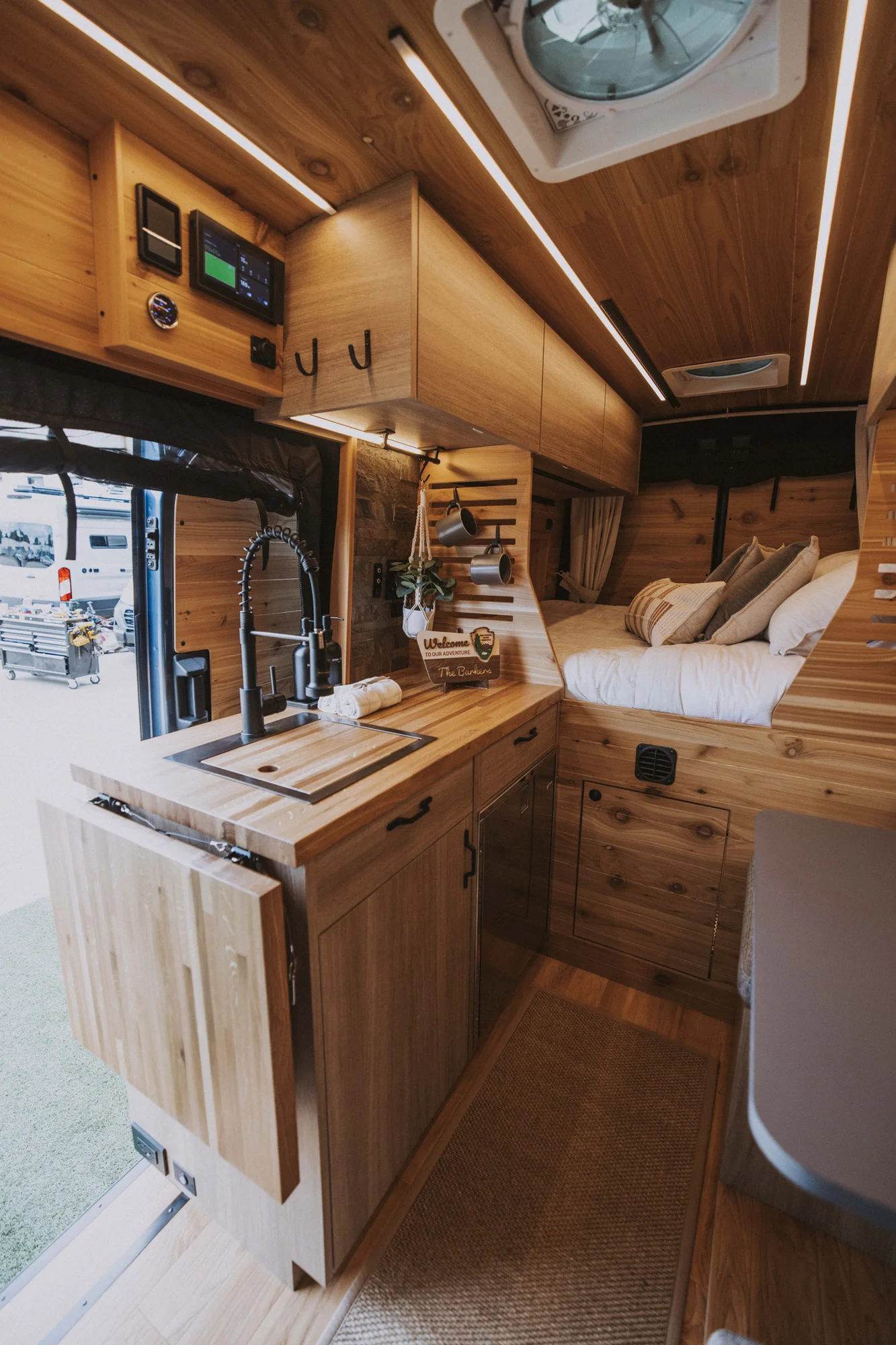 The Drifter 101 custom Ford Transit campervan built for Ken and Terry by Drifter Vans, with cedar plank walls, ambient lighting, and a compact dinette