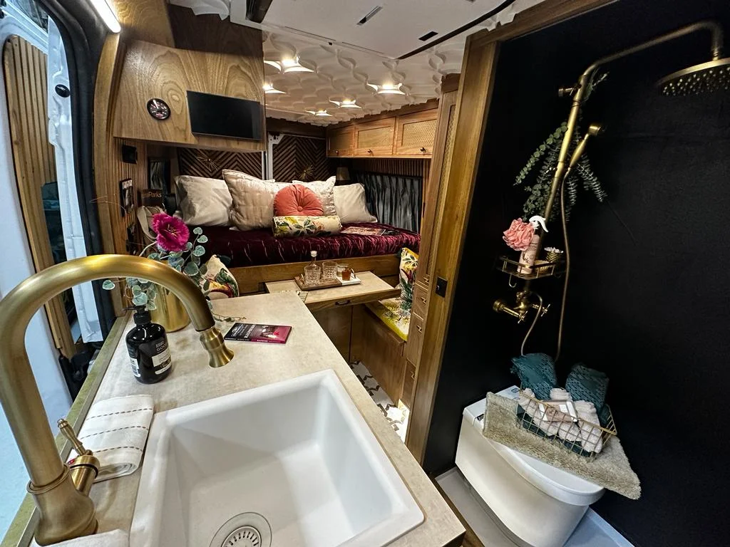 The Drifter 101 custom Ram ProMaster campervan built for Stephanie by Drifter Vans, Nomadik layout with a retro interior, velvet bedding, floral textiles, and brass fixtures