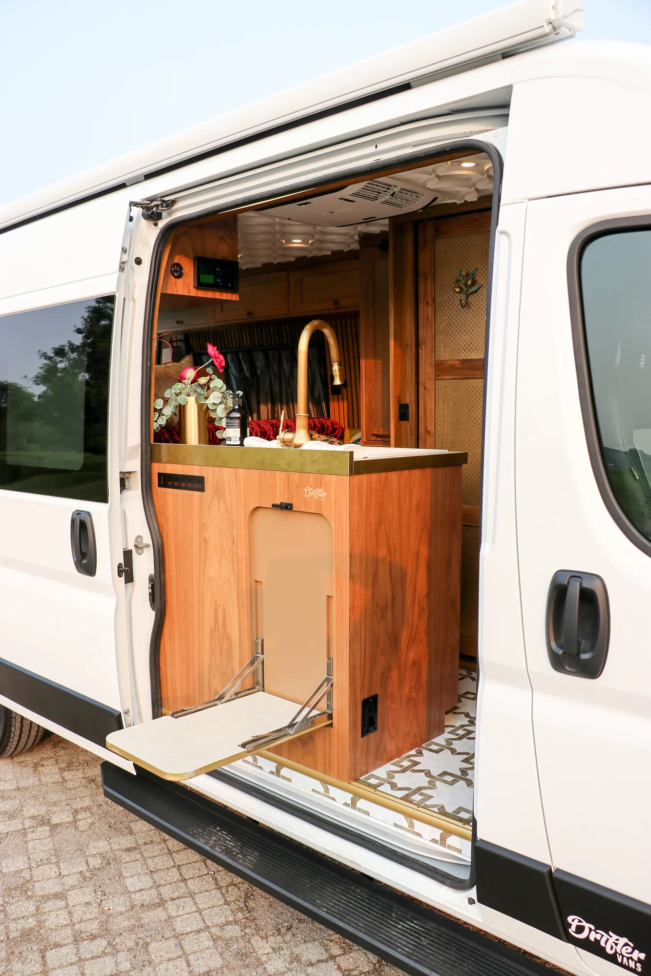The Drifter 101 custom Ram ProMaster campervan built for Stephanie by Drifter Vans, Nomadik layout with a retro interior, velvet bedding, floral textiles, and brass fixtures