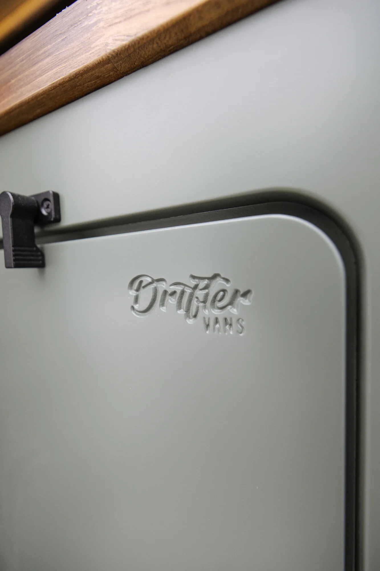The Drifter 101 custom Ford Transit campervan built for Agnes by Drifter Vans, Drifter layout with sage green cabinetry, a Tetra shower, and Trelino composting toilet