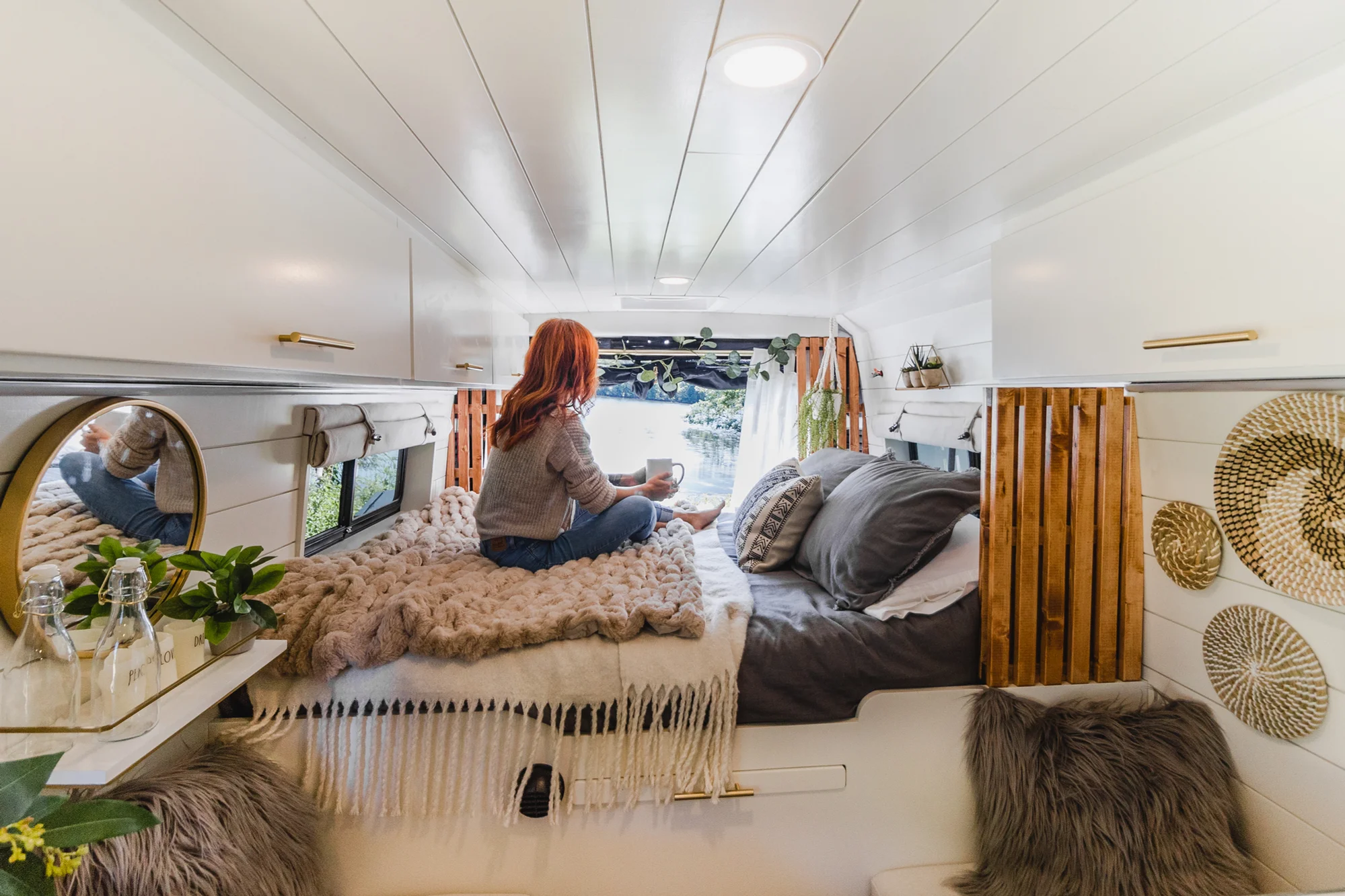 The Drifter 101 custom Ram ProMaster campervan built for Tracy by Drifter Vans, with an earthy boho interior, gold showerhead, and warm wood paneling