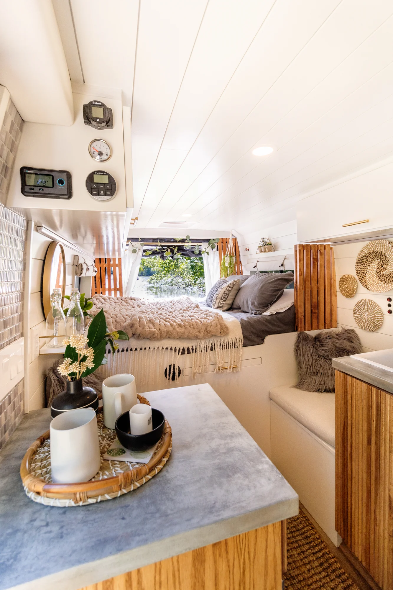The Drifter 101 custom Ram ProMaster campervan built for Tracy by Drifter Vans, with an earthy boho interior, gold showerhead, and warm wood paneling
